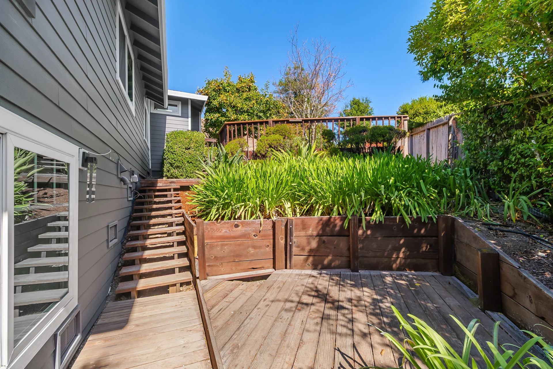 Terraced garden with wood retaining walls, decking and privacy fencing