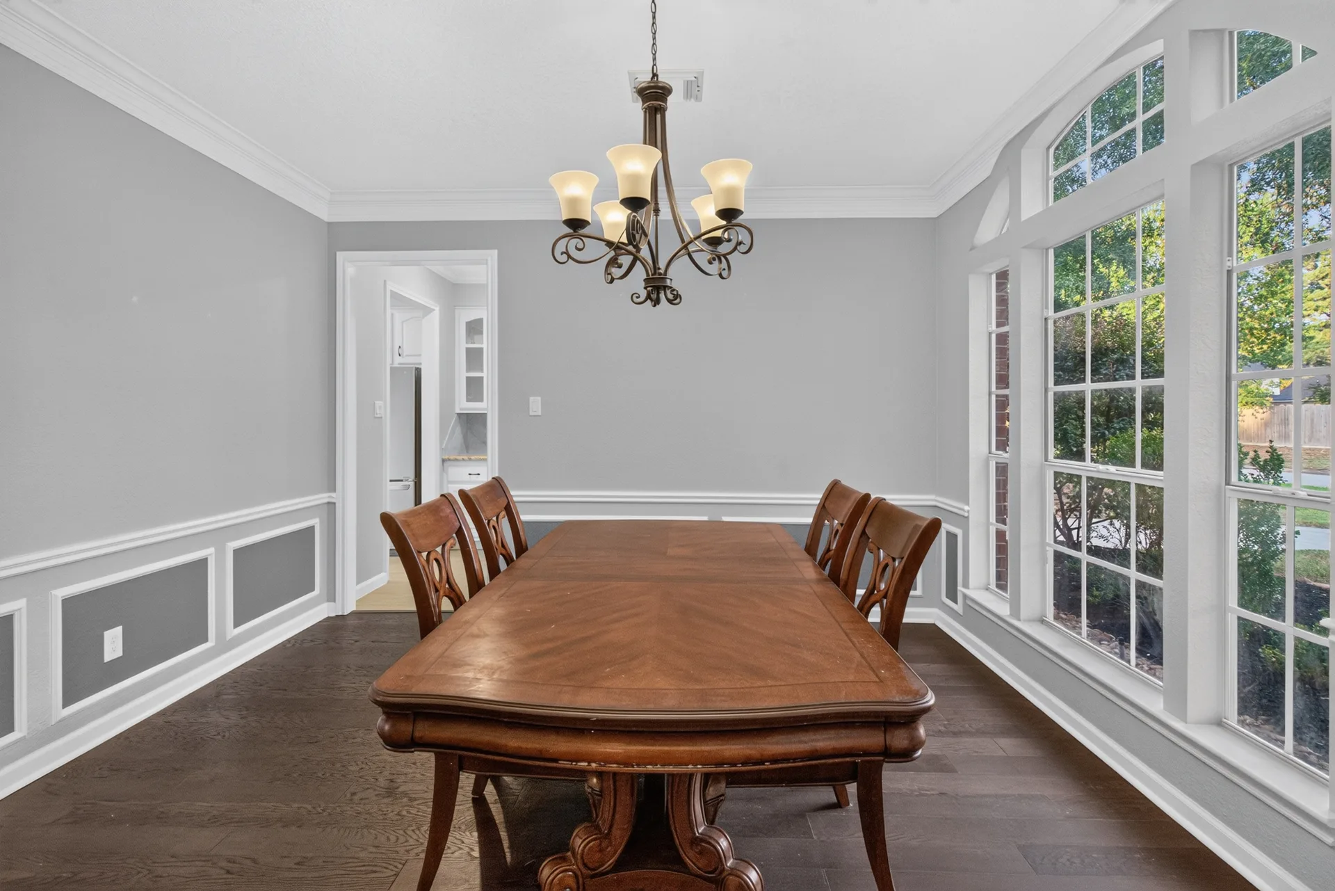 Formal dining room with wainscoting, crown molding, and a large window