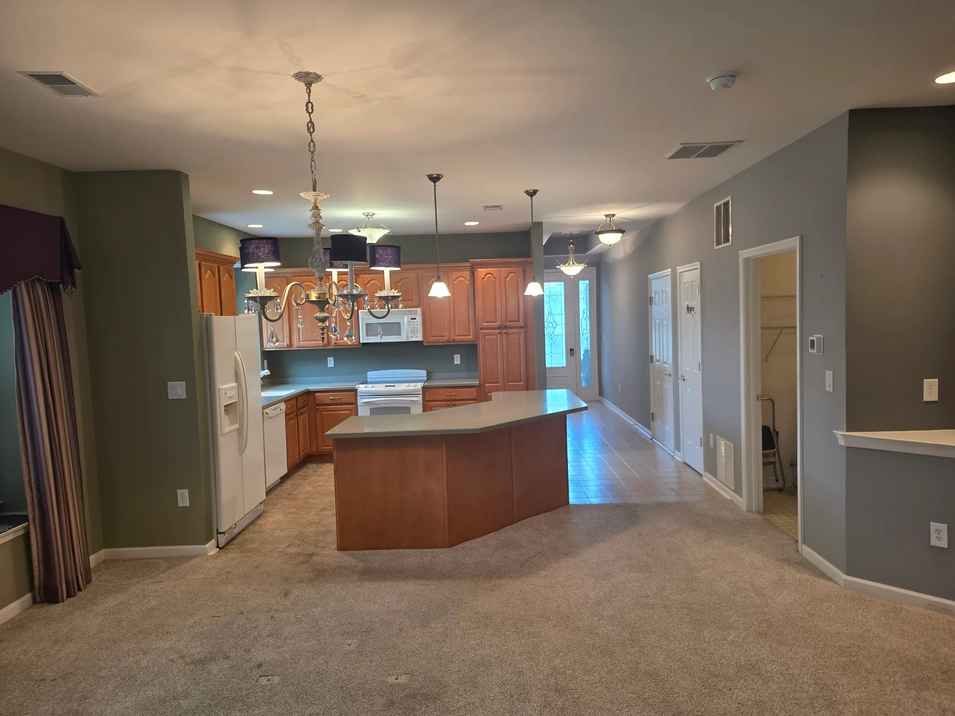 Open-plan kitchen and living area with wood cabinetry and island