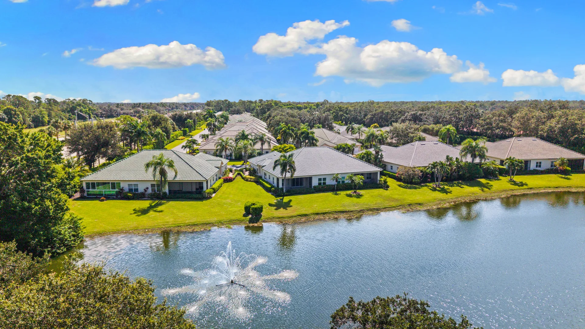 Aerial of single-story homes around central lake