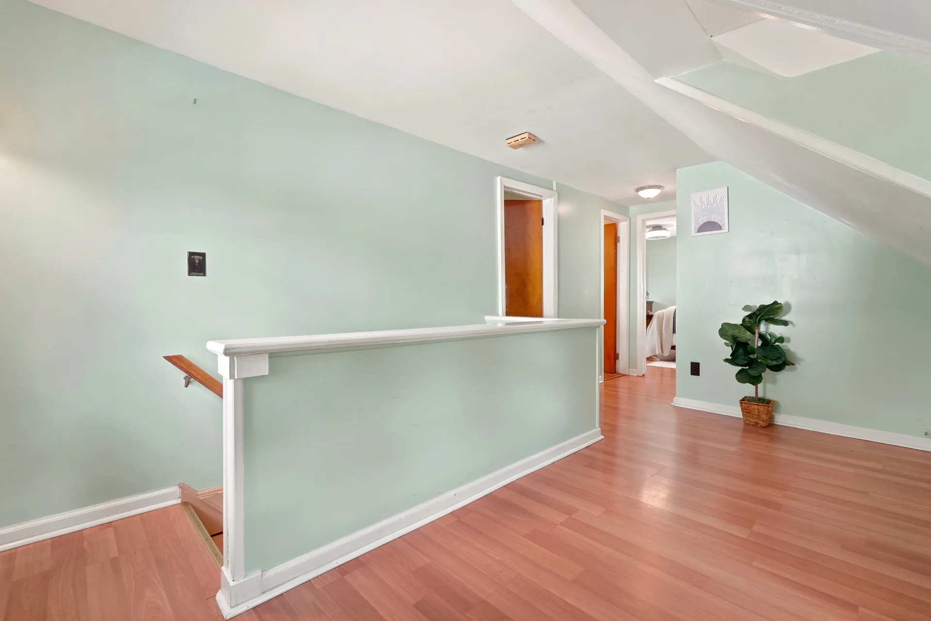 Second-floor hallway landing with white railing and light green walls