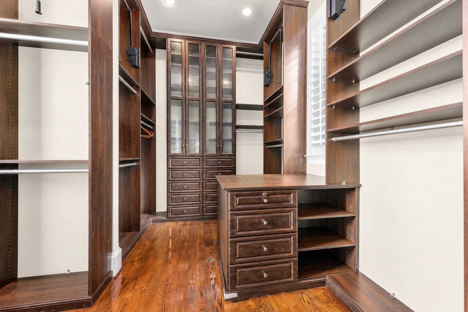 Walk-in closet with custom dark wood cabinetry