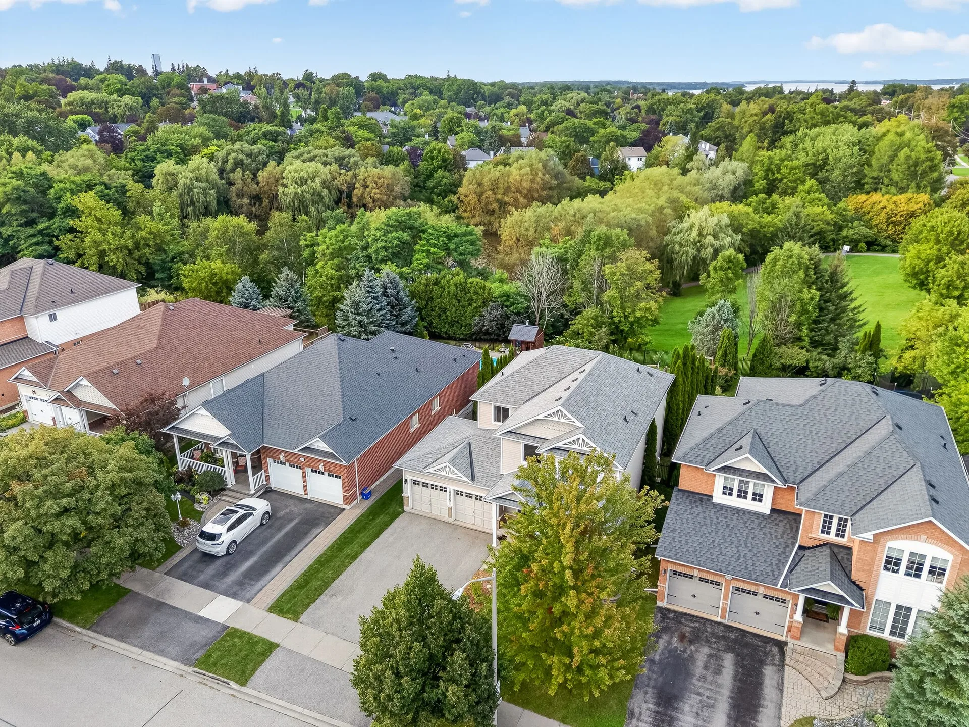 A drone aerial view of the residential street around 459 Victoria in Port Perry, with family homes, driveways and green space at the edge of the neighbourhood