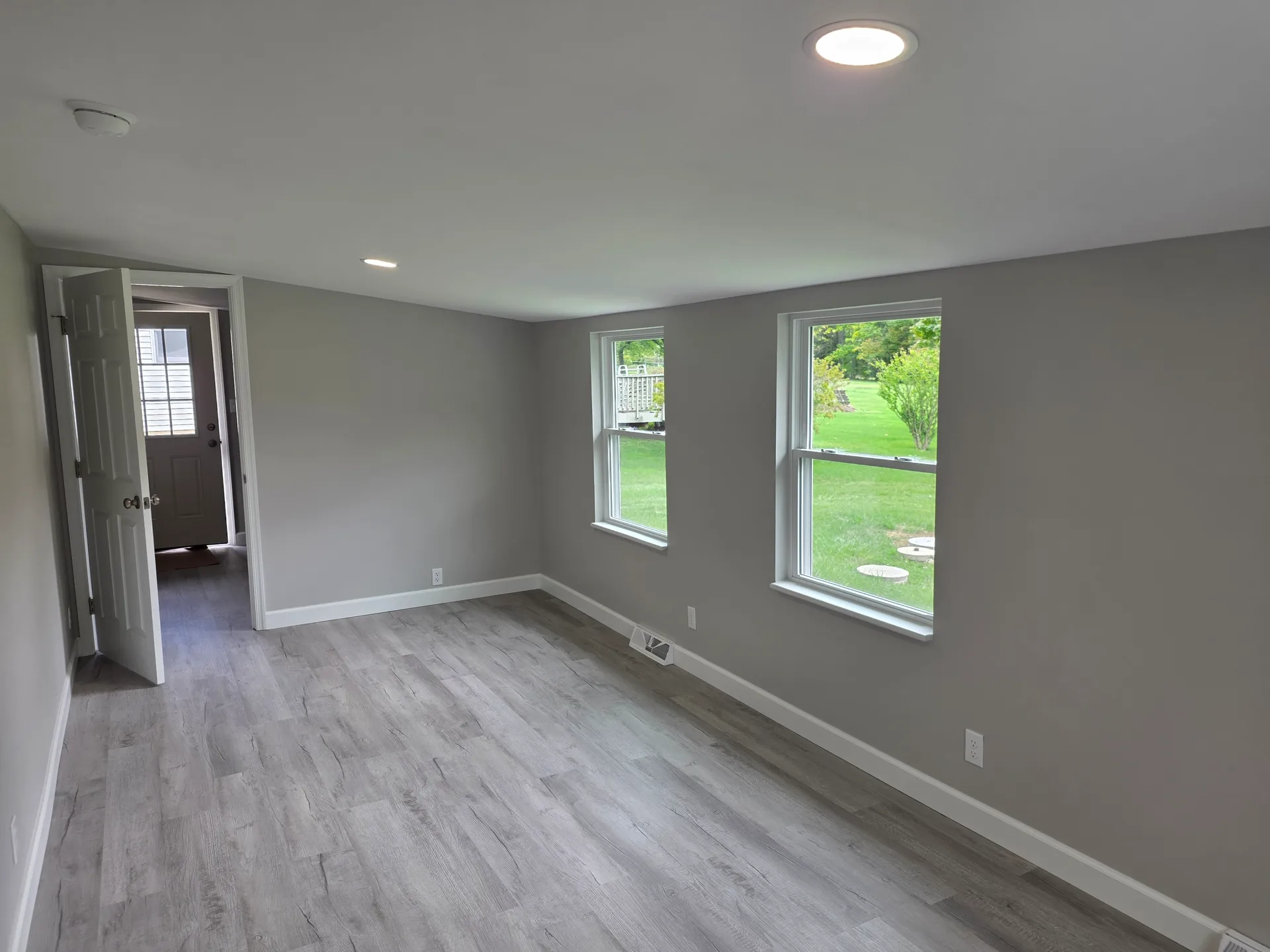 Bright bedroom with two windows overlooking the backyard