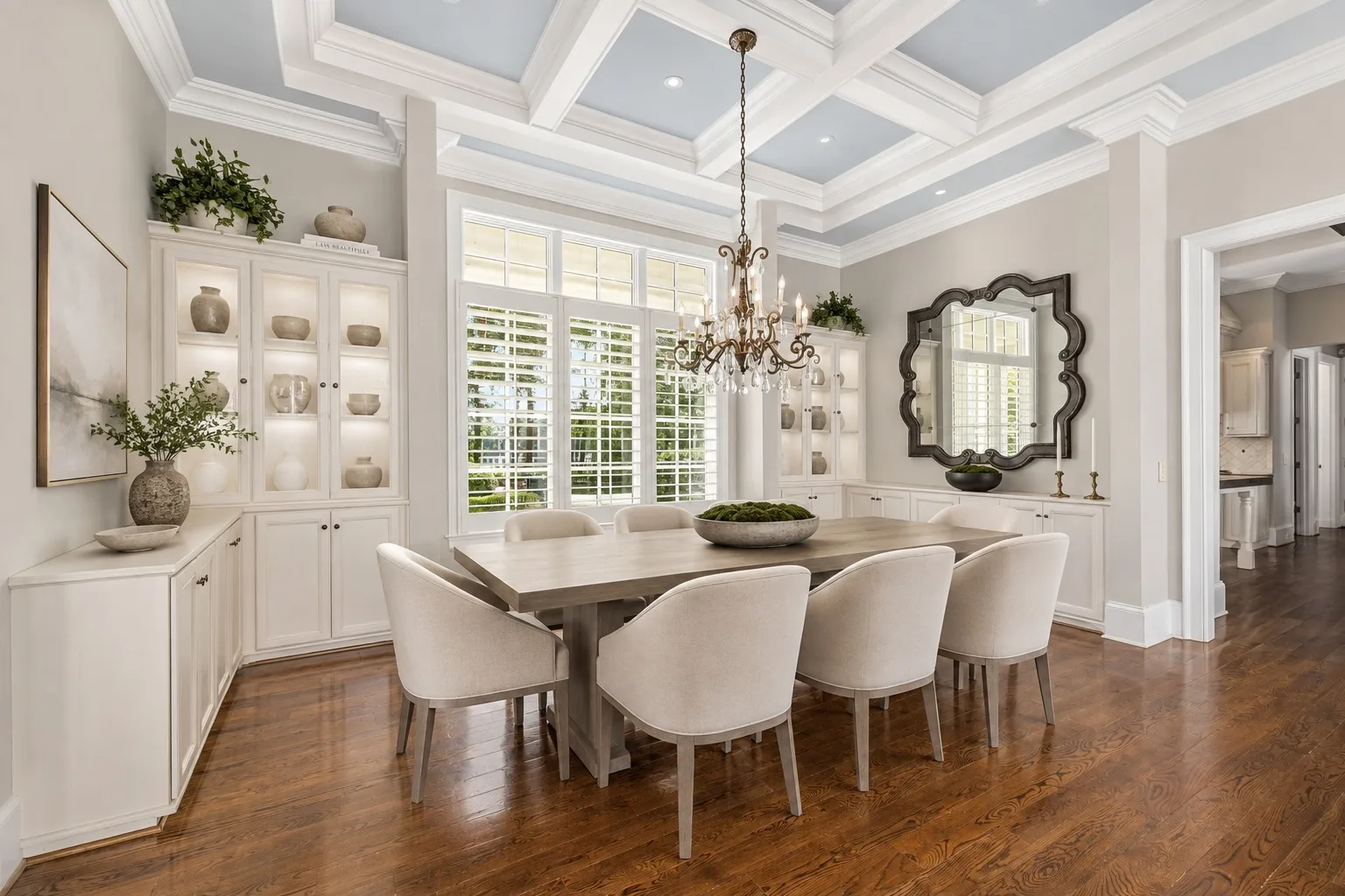 Formal dining room with coffered ceiling, hardwood floors, and large windows