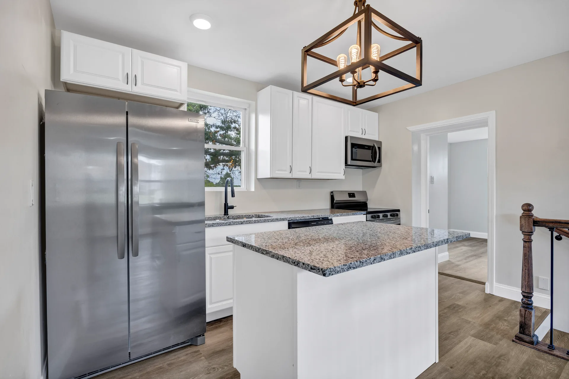 Kitchen island with granite counter and stainless appliances