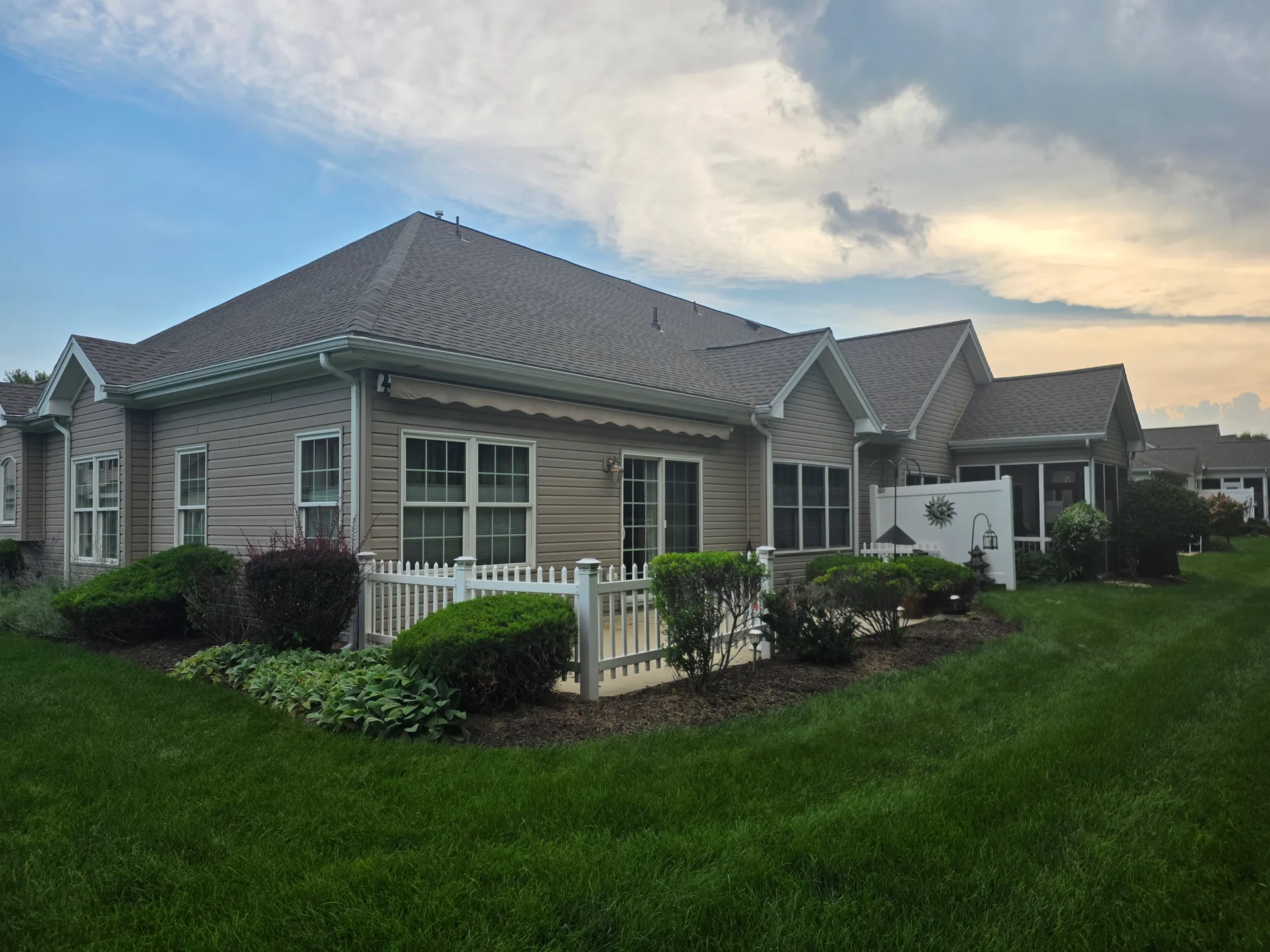 Private fenced patio with an extended electric awning at golden hour