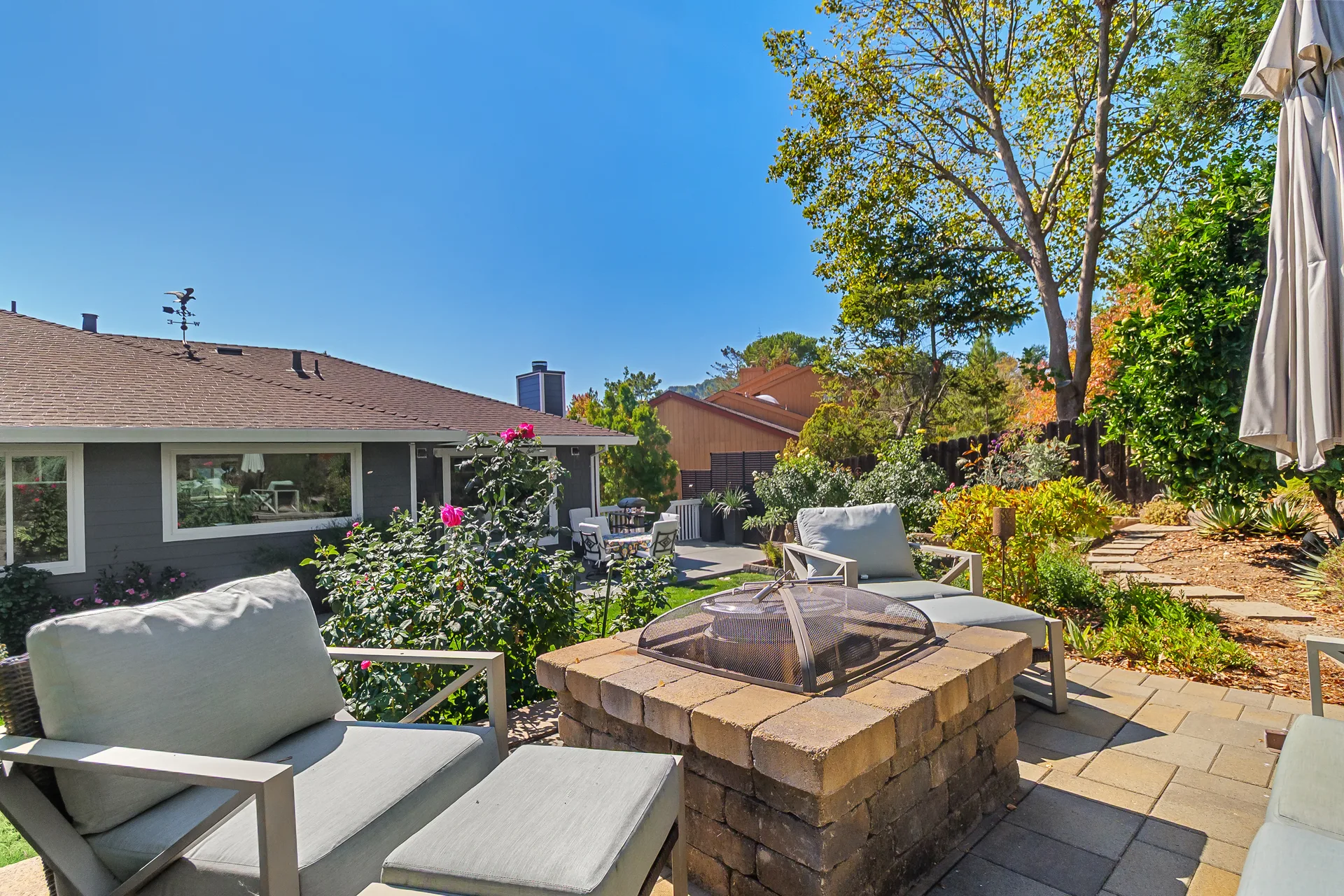 Backyard of 10 Santa Yorma Ct with a custom paver patio, built-in stone fire pit, and terraced garden