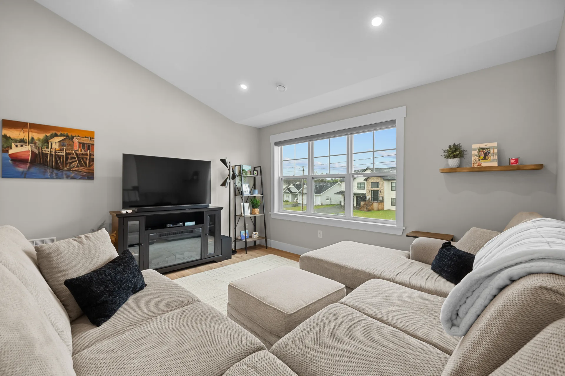 Spacious living room with vaulted ceiling and light wood flooring