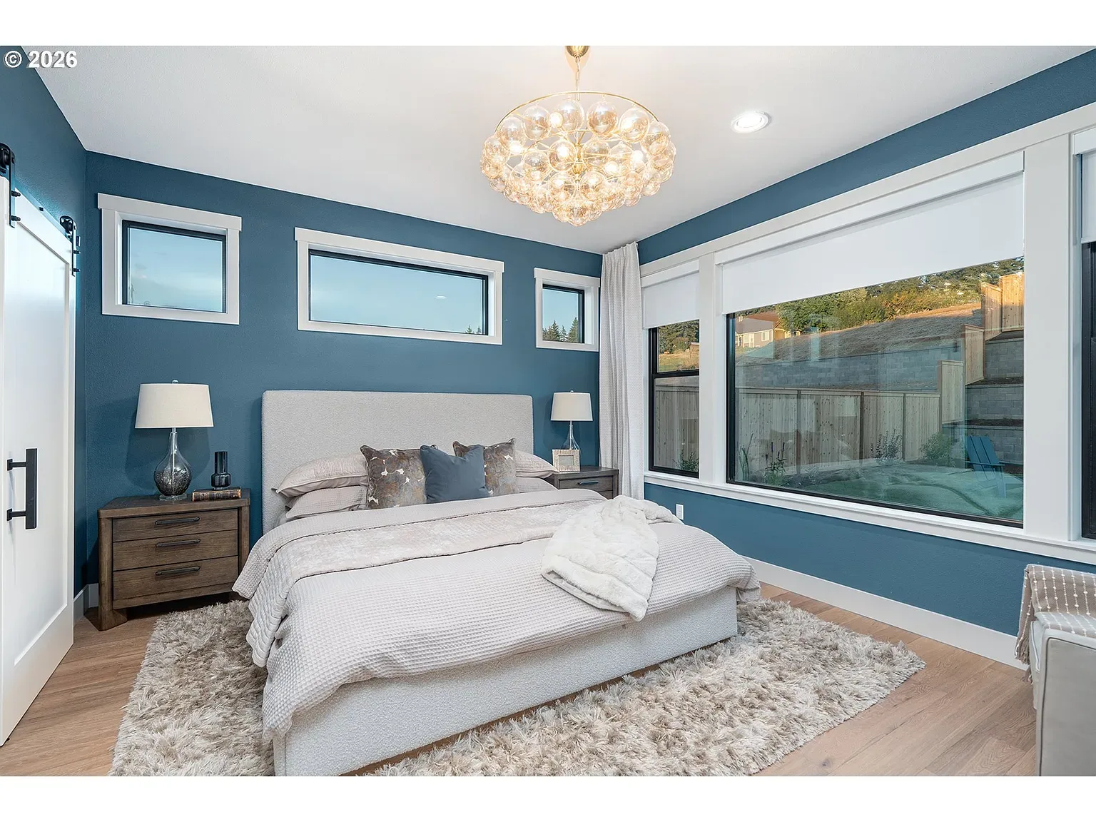 Guest bedroom: A deep blue feature wall and tall natural light