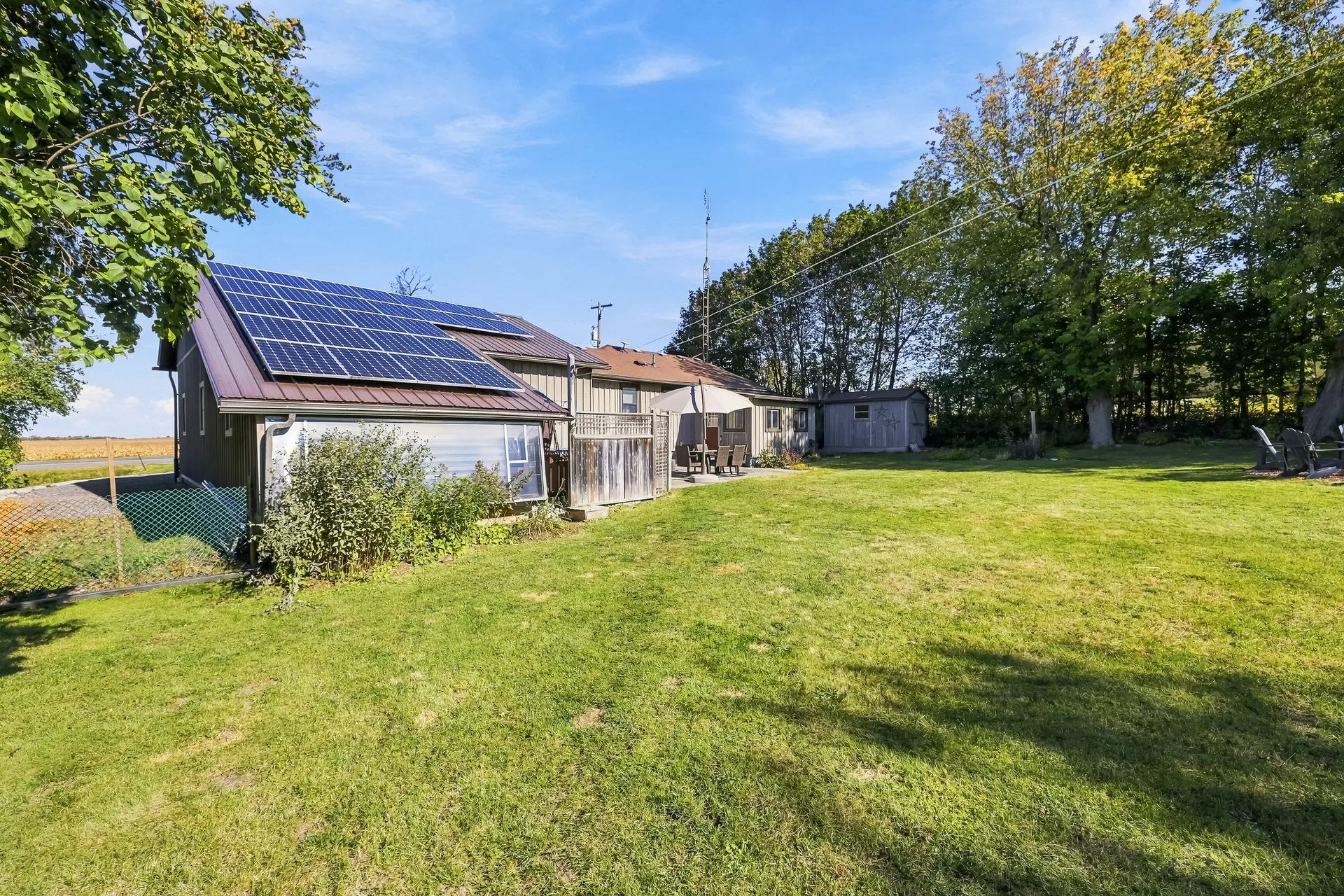 Backyard of the home with metal roof and integrated solar panels