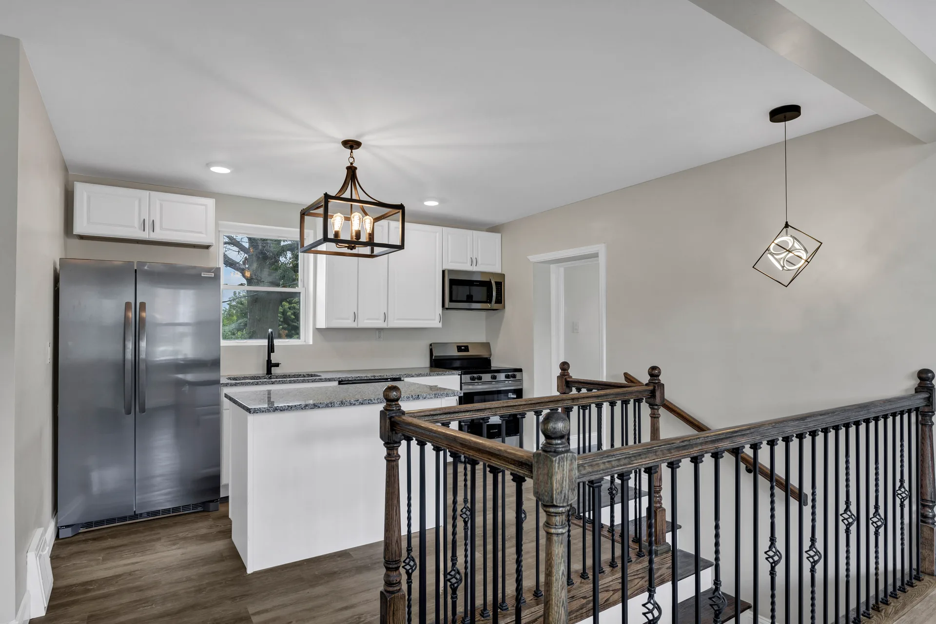 Renovated kitchen with white cabinets and granite countertops