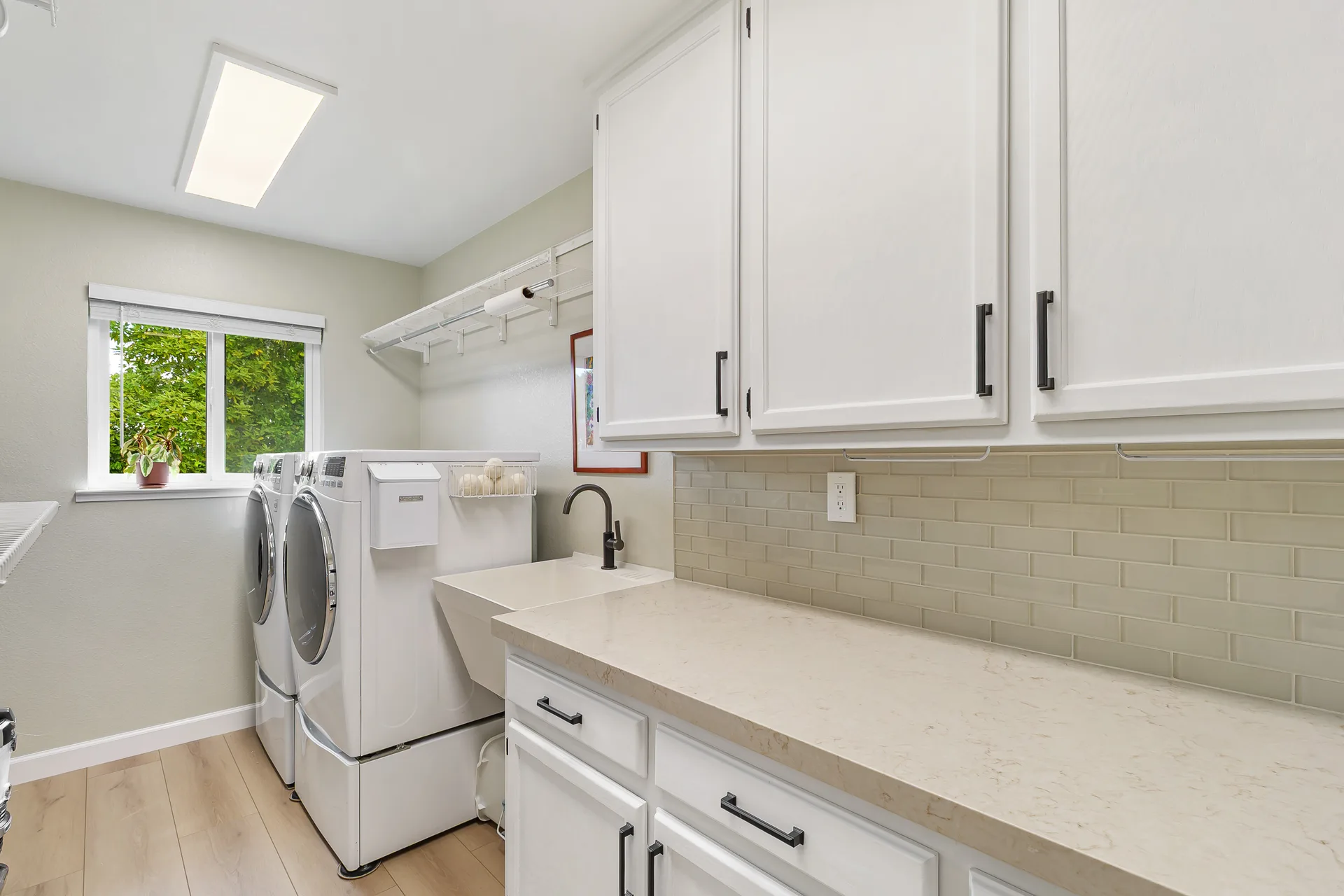 2025 renovated laundry suite with Taj Royale quartz countertops, subway tile, and white shaker cabinetry