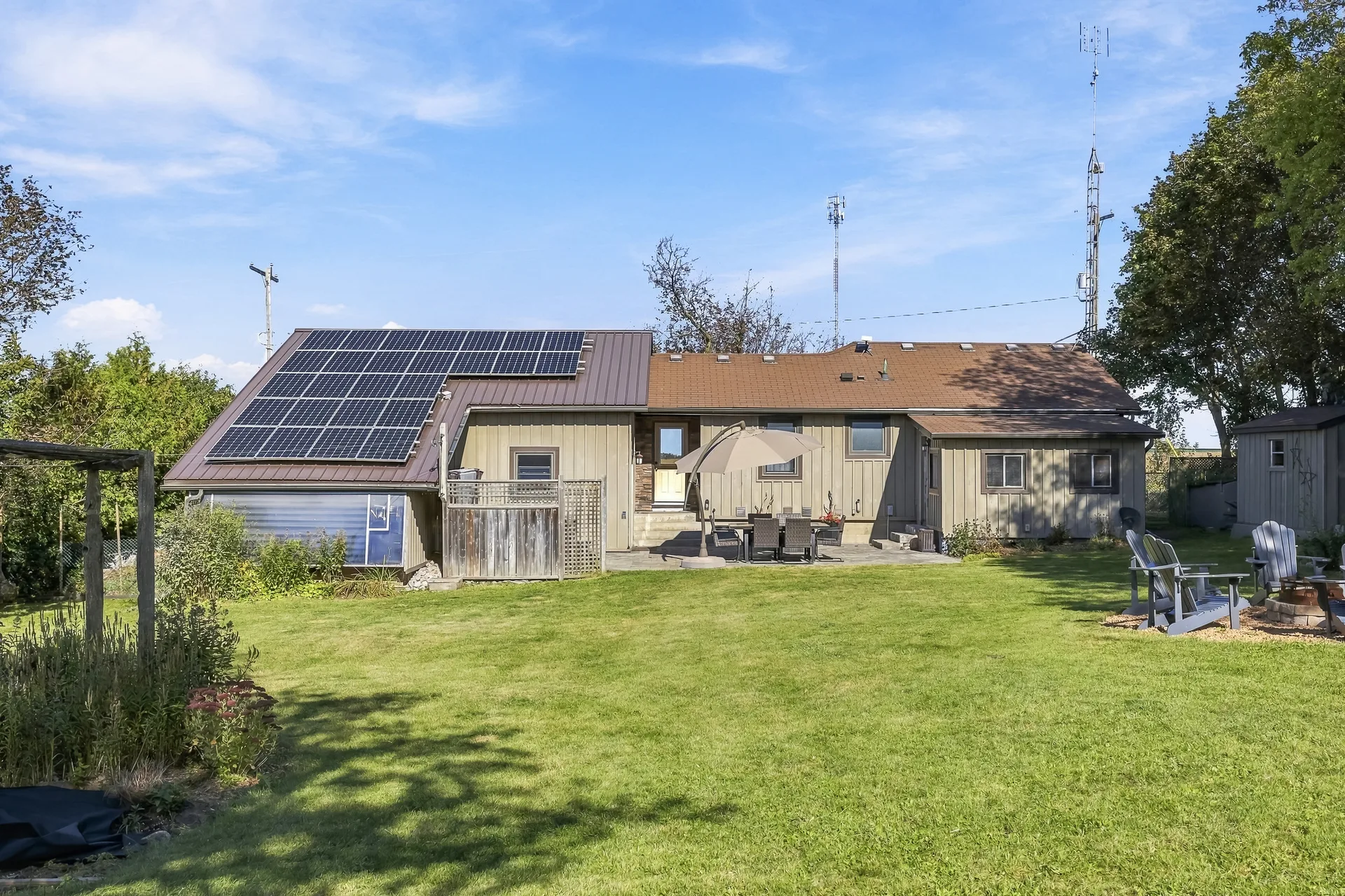 Backyard patio and lawn with solar panels visible on the metal roof
