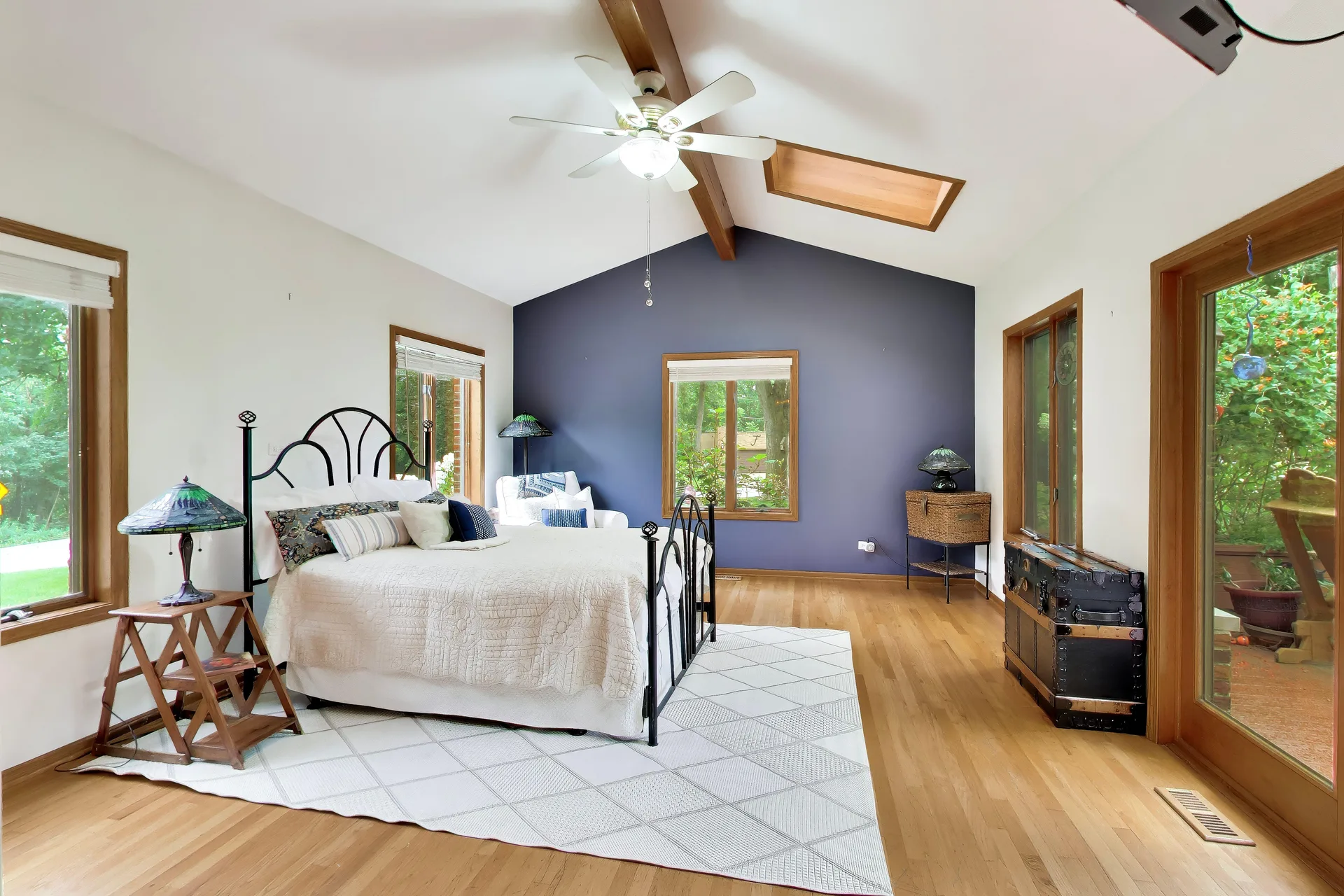 Primary bedroom with vaulted ceiling and navy accent wall