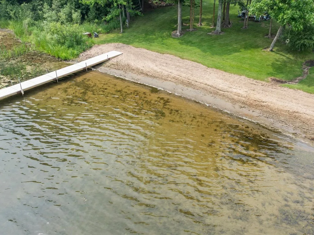 Aerial photograph of the long private sandy beach and white dock