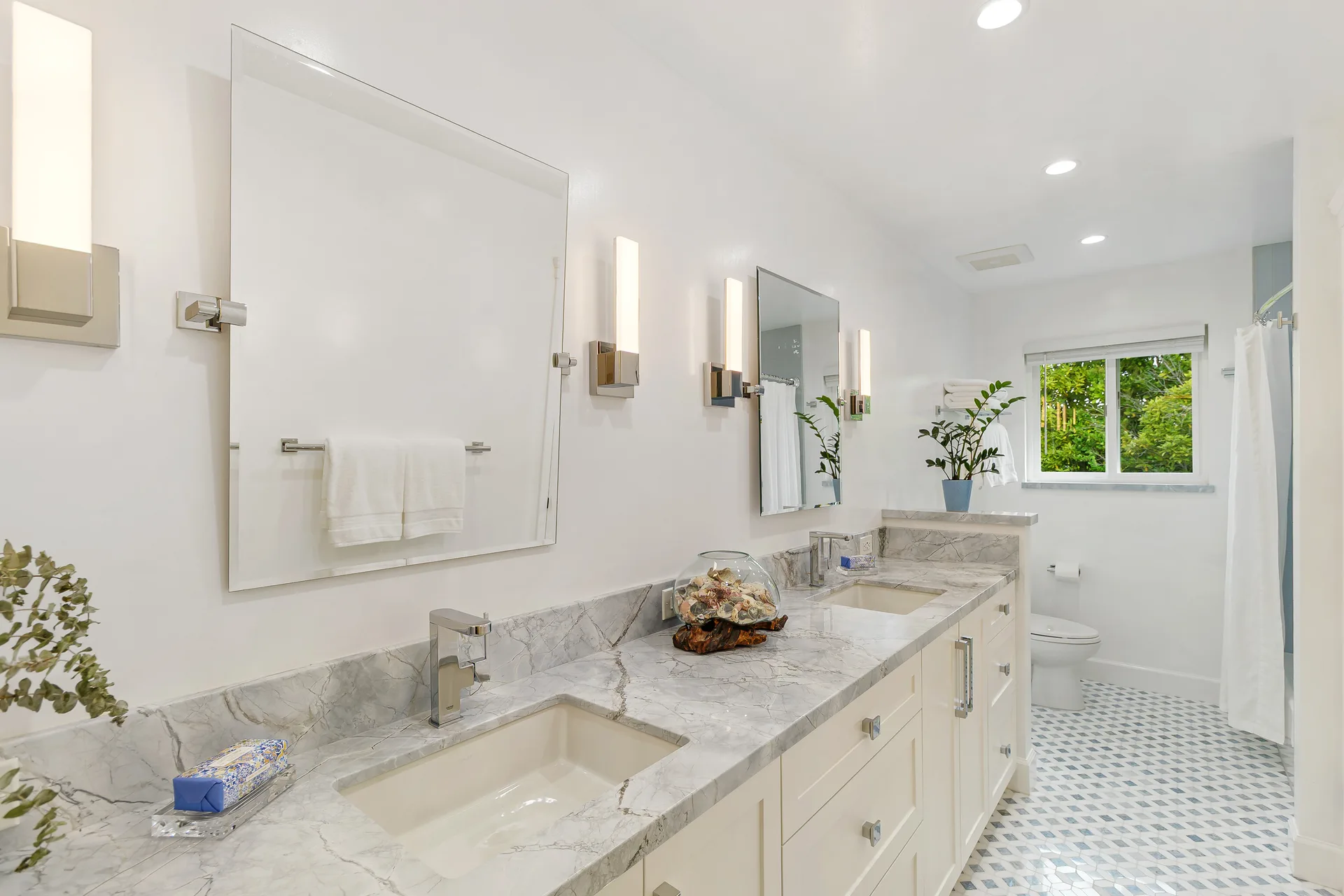 Renovated bathroom with custom vanity, marble countertop and mosaic tile flooring