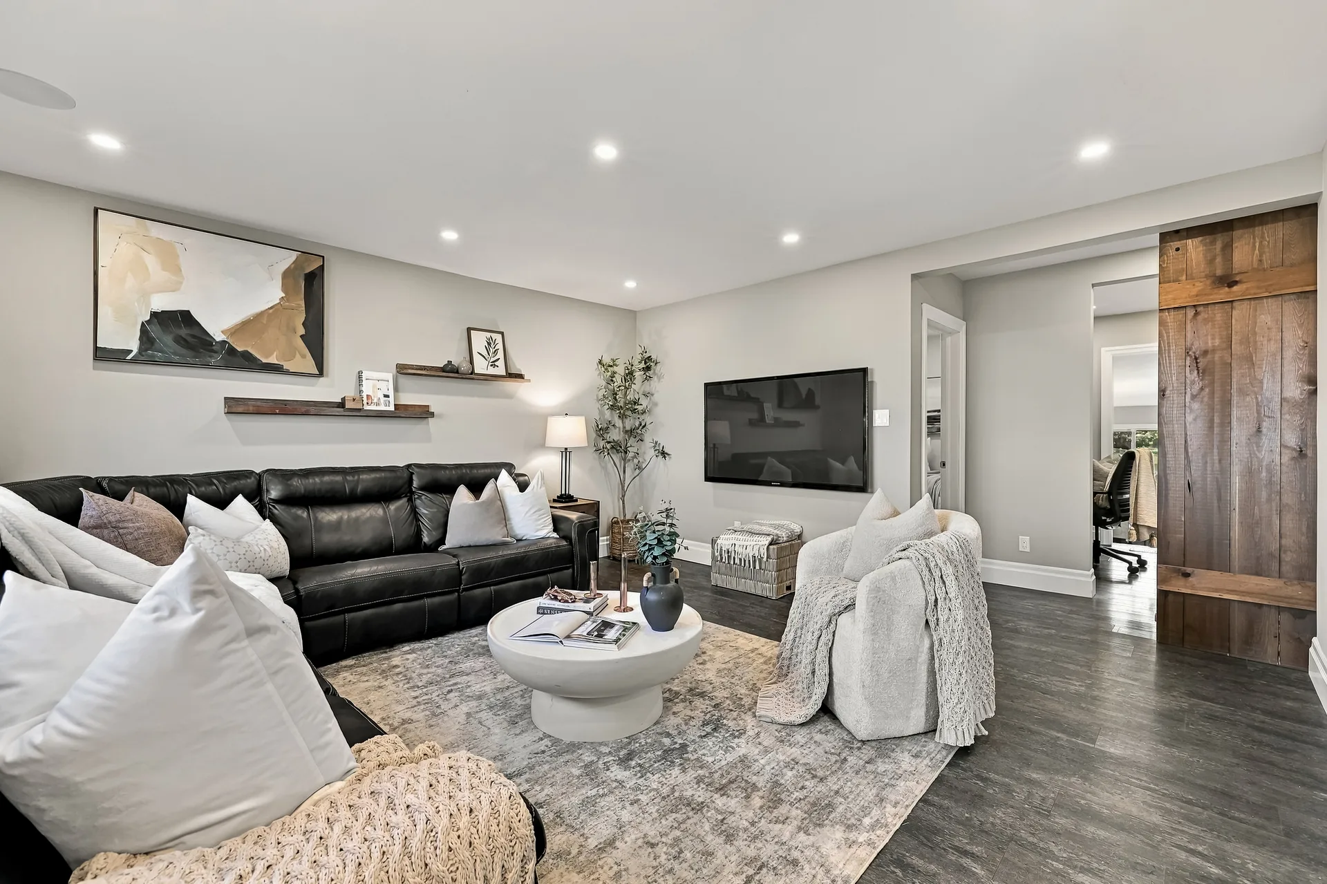 Contemporary living room with sectional, accent chairs and barn door