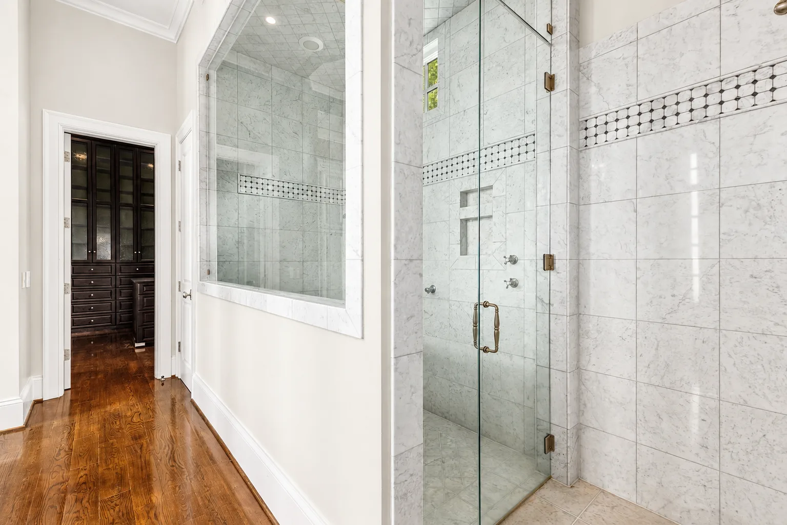 Bathroom with marble tiling and walk-in closet view