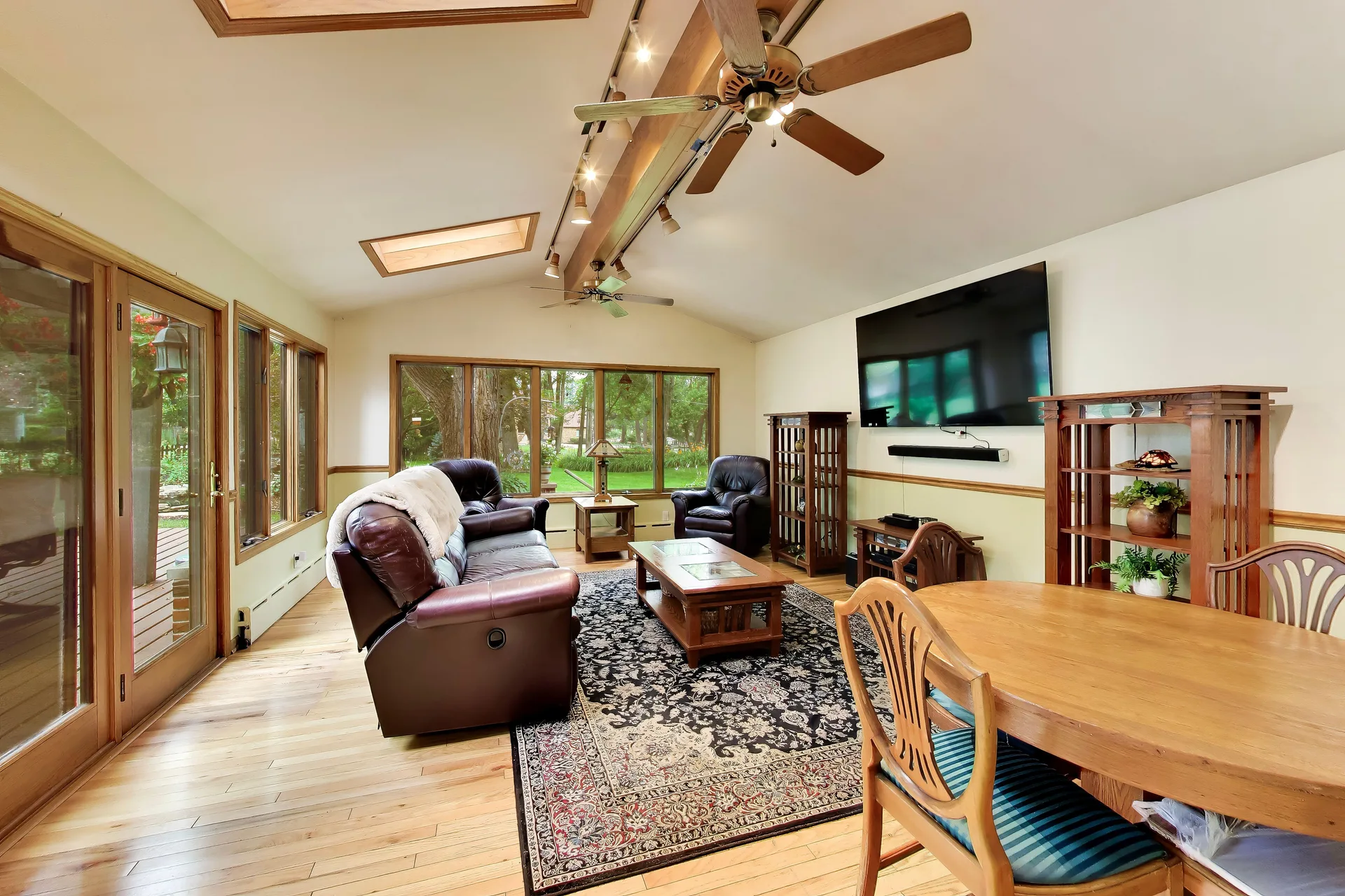 Sunroom at 3708 Cooper Place with vaulted wooden-beam ceiling and skylights over hardwood floors