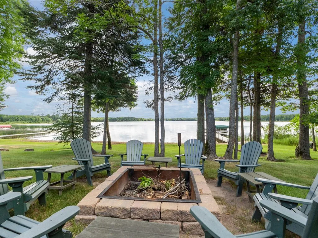 Lakeside firepit area with Adirondack chairs looking over the lawn