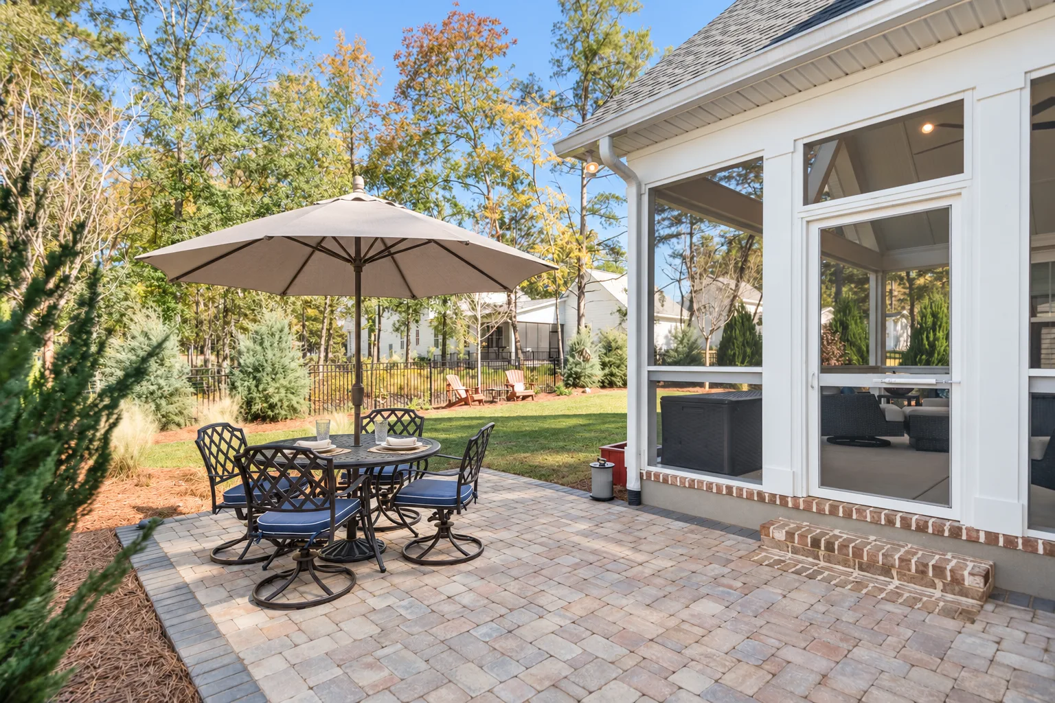 Paver patio with an outdoor dining set off the screened porch