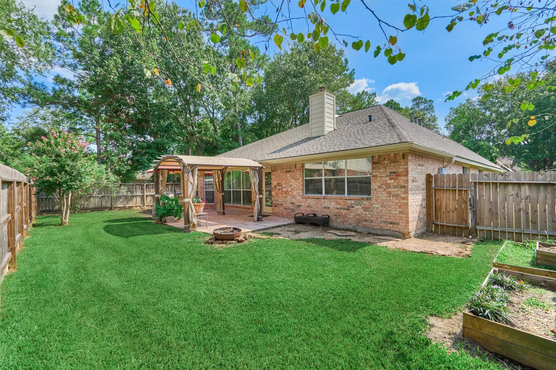Backyard with flagstone patio area, wooden fence, and brick exterior