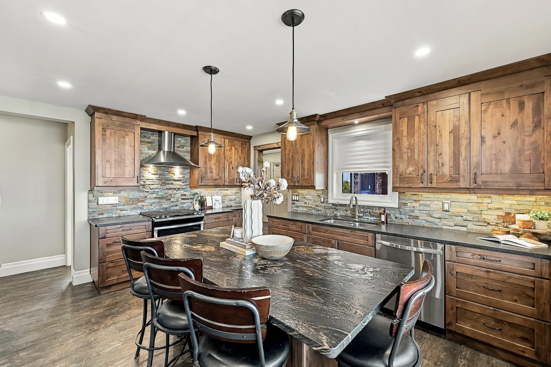 Kitchen island with leathered granite countertop and bar seating