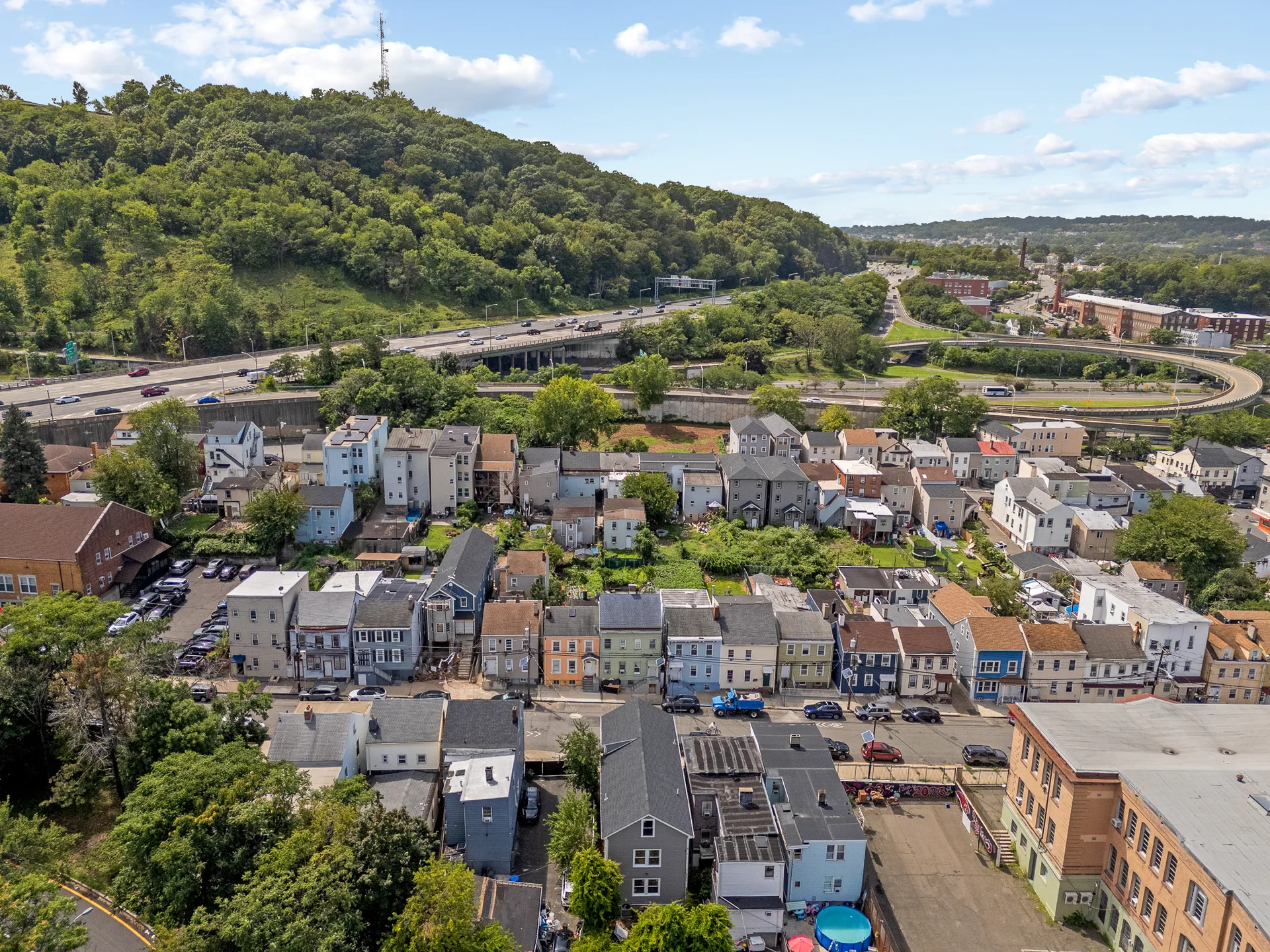 Drone aerial overview of the residential neighborhood around 113 Marshall St, near highway infrastructure.