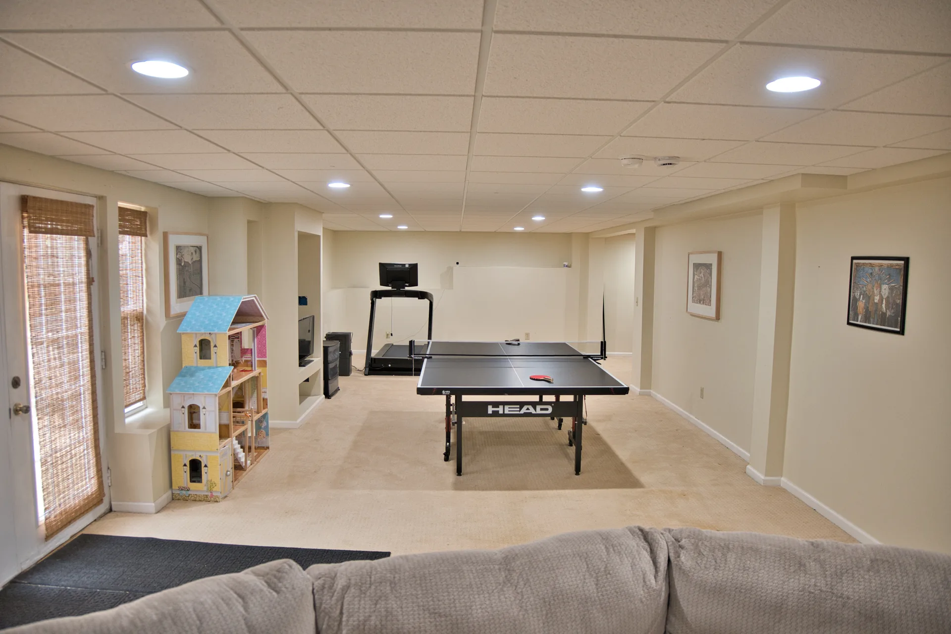 Finished basement recreation room with ping pong table and treadmill