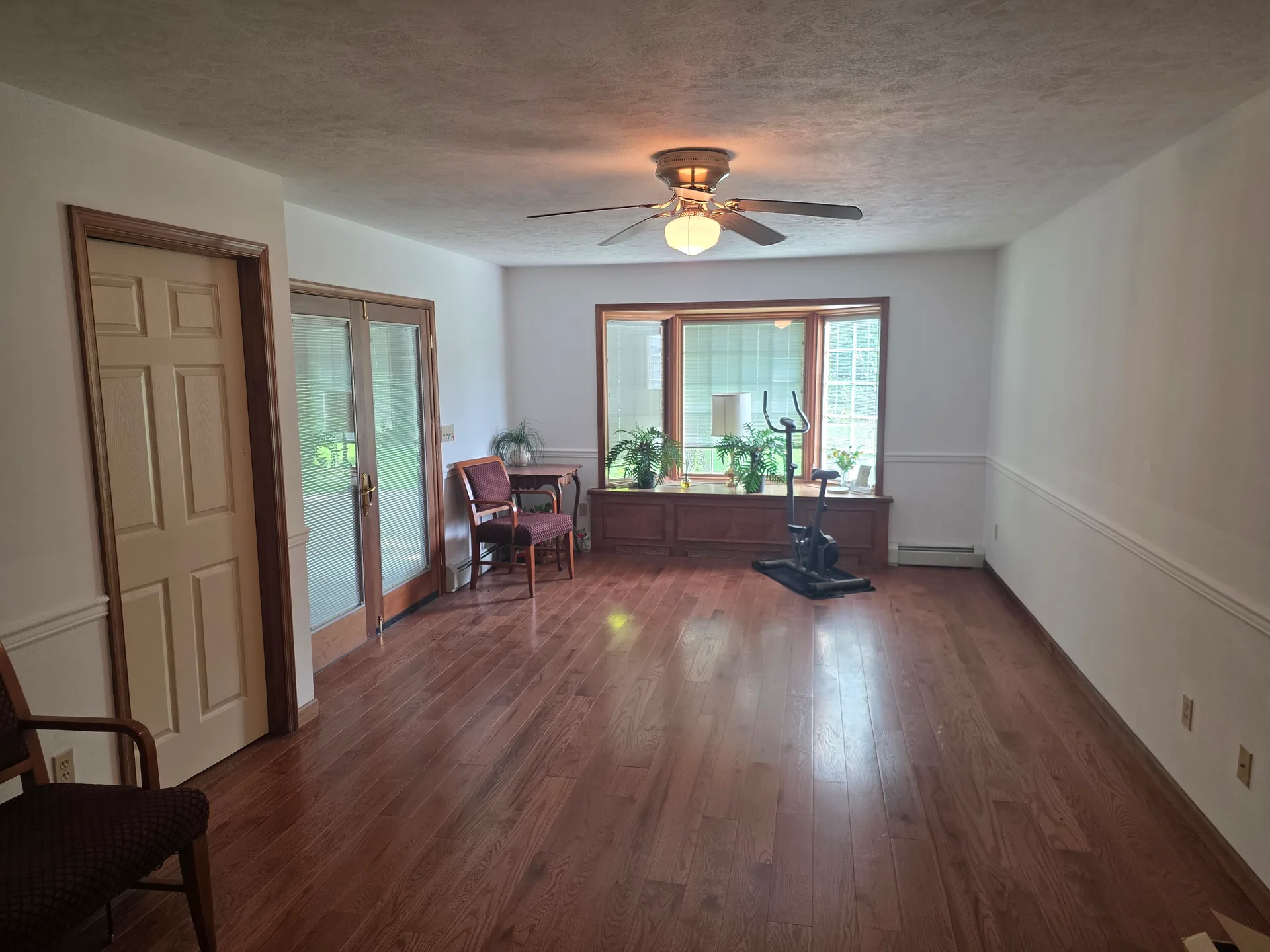 Spacious bedroom with window seat, bay window, and hardwood flooring