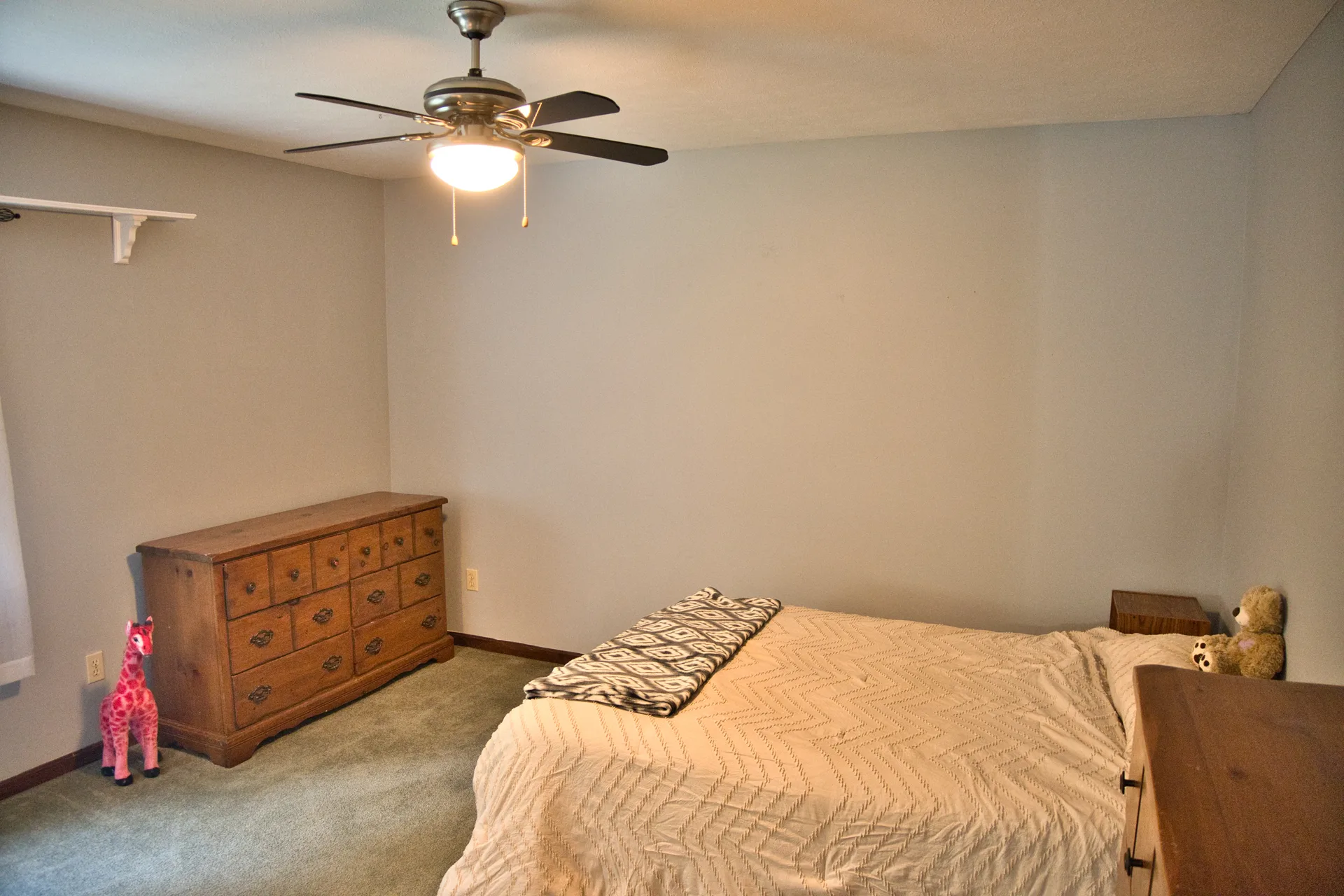 Secondary bedroom with a queen bed and light grey walls