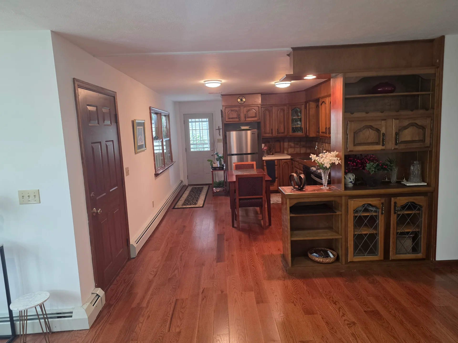Kitchen and dining area with wooden cabinetry and hardwood flooring