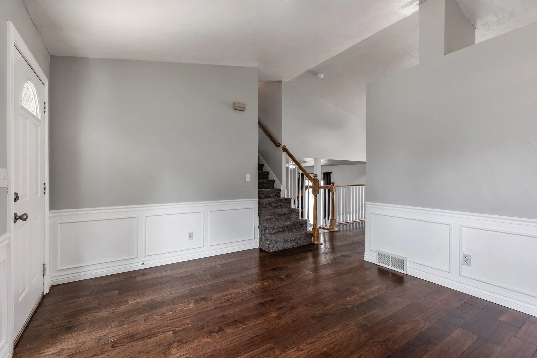 Foyer and entryway with wainscoting and staircase