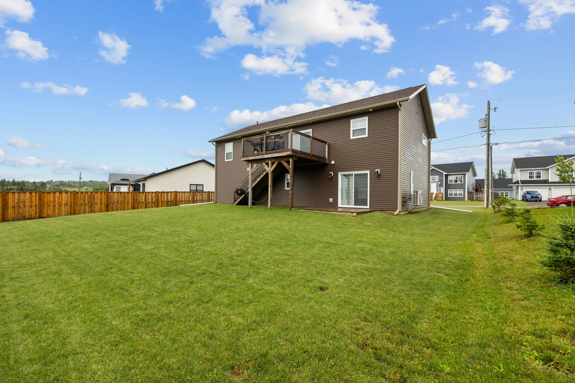 Backyard with raised wooden deck and spacious lawn
