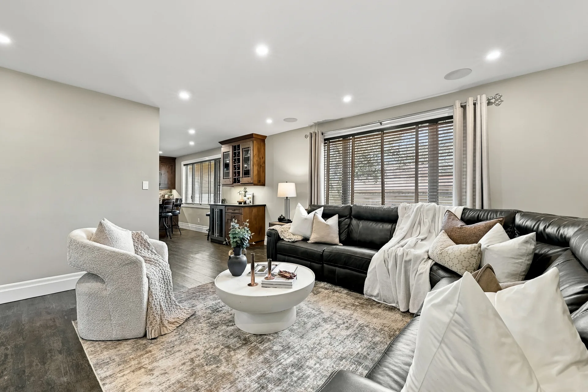 Open-concept living room with sectional sofa and curved armchair