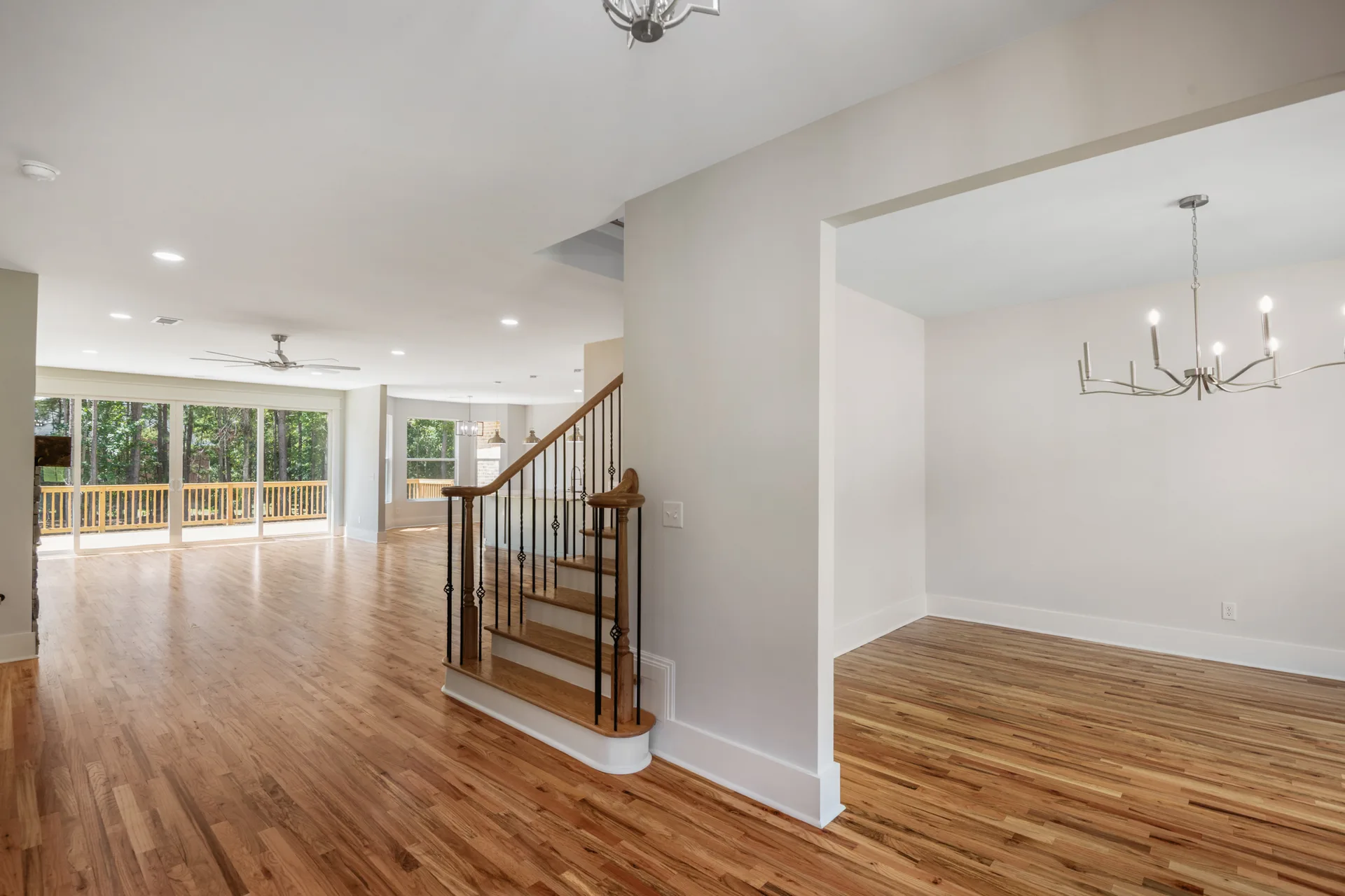 Open living and dining area with staircase and rear wall of glass