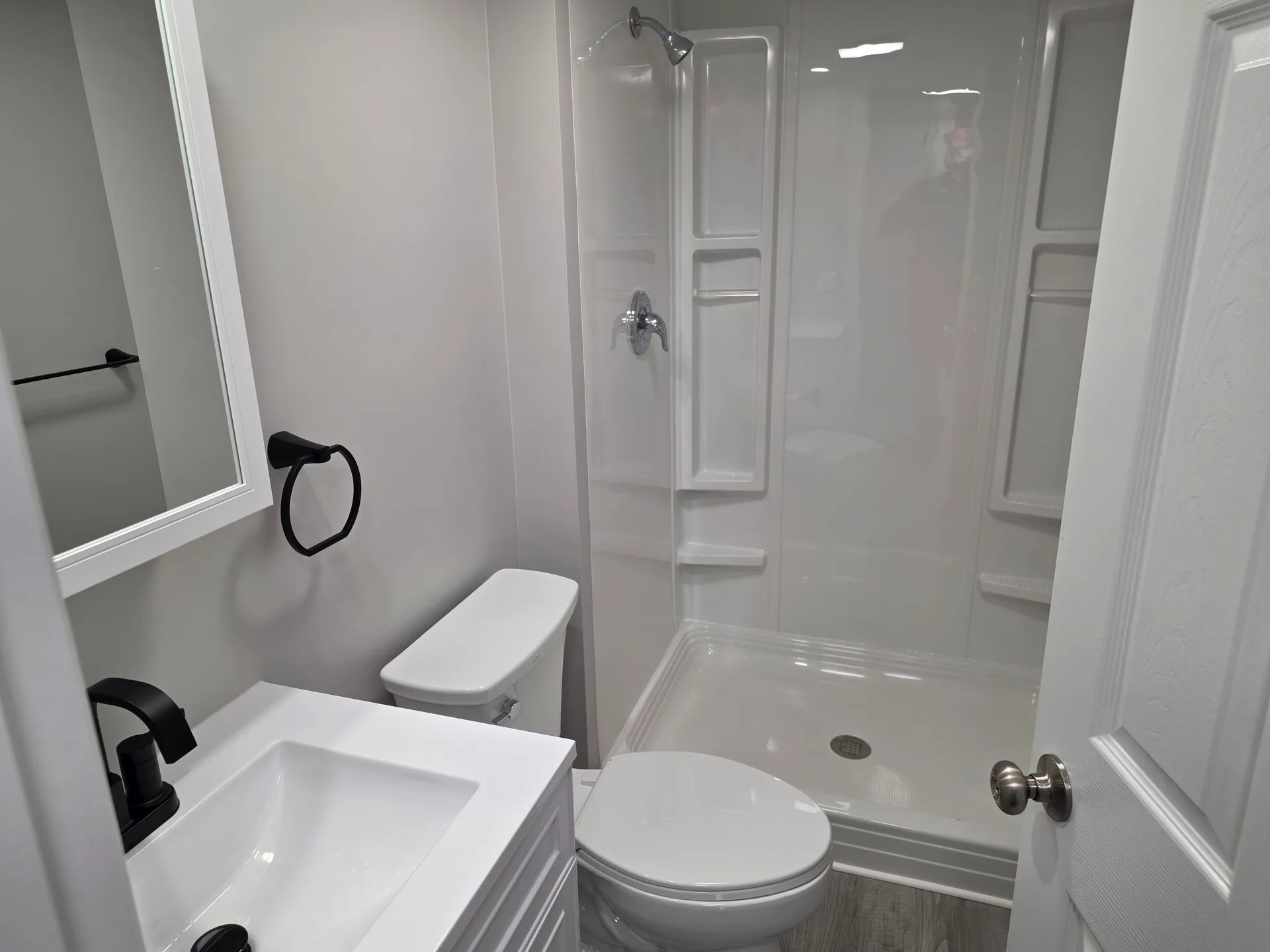 Updated guest bathroom with white vanity and acrylic shower