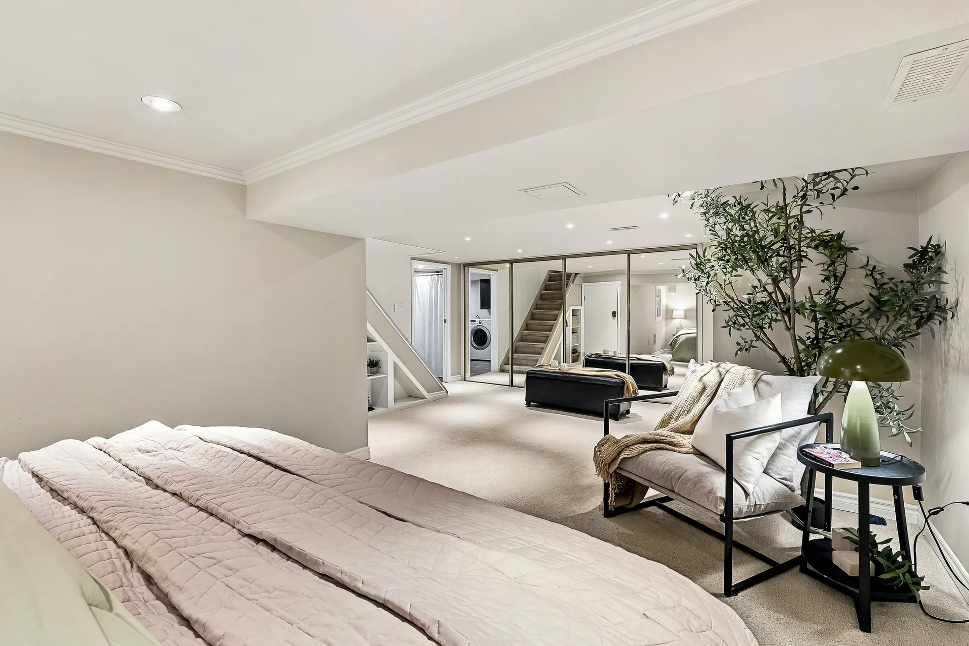 Lower-level bedroom or recreation room with ottoman seating