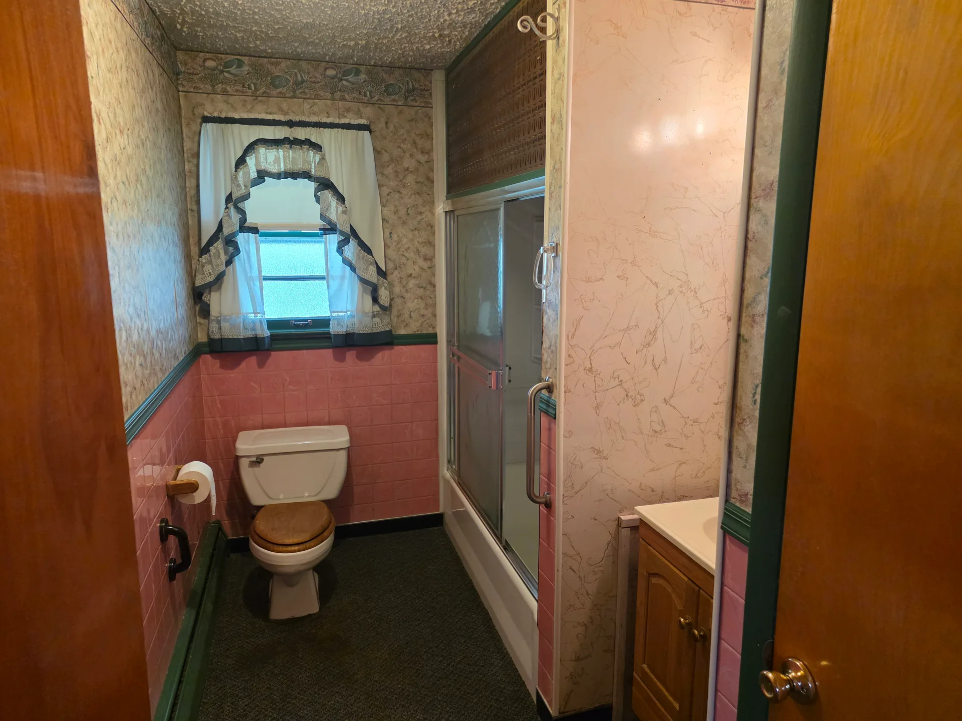 Bathroom with pink tile wainscoting and shower-tub combo