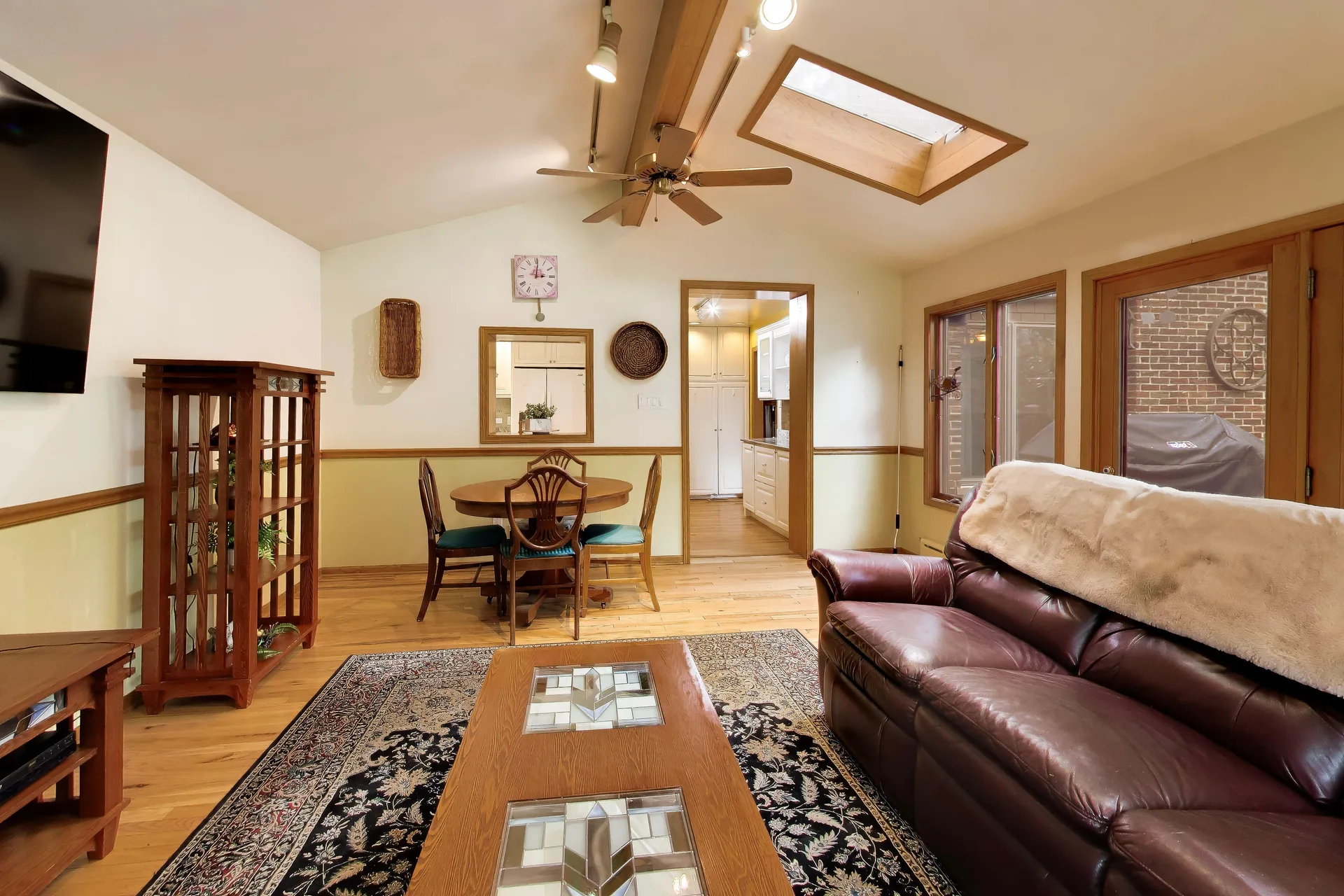 Open living and dining space with vaulted beam ceiling