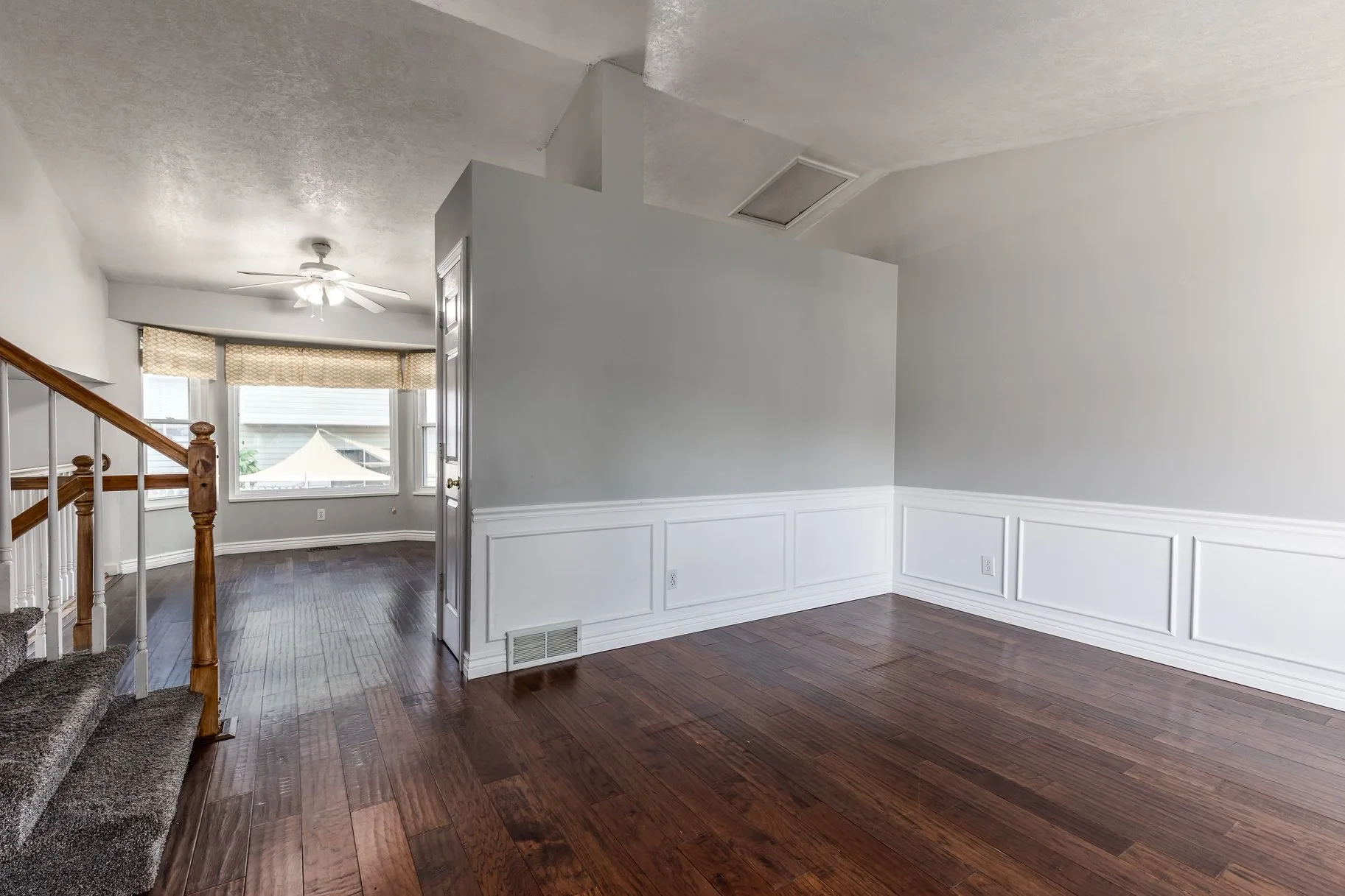 Living room with white wainscoting and bay window