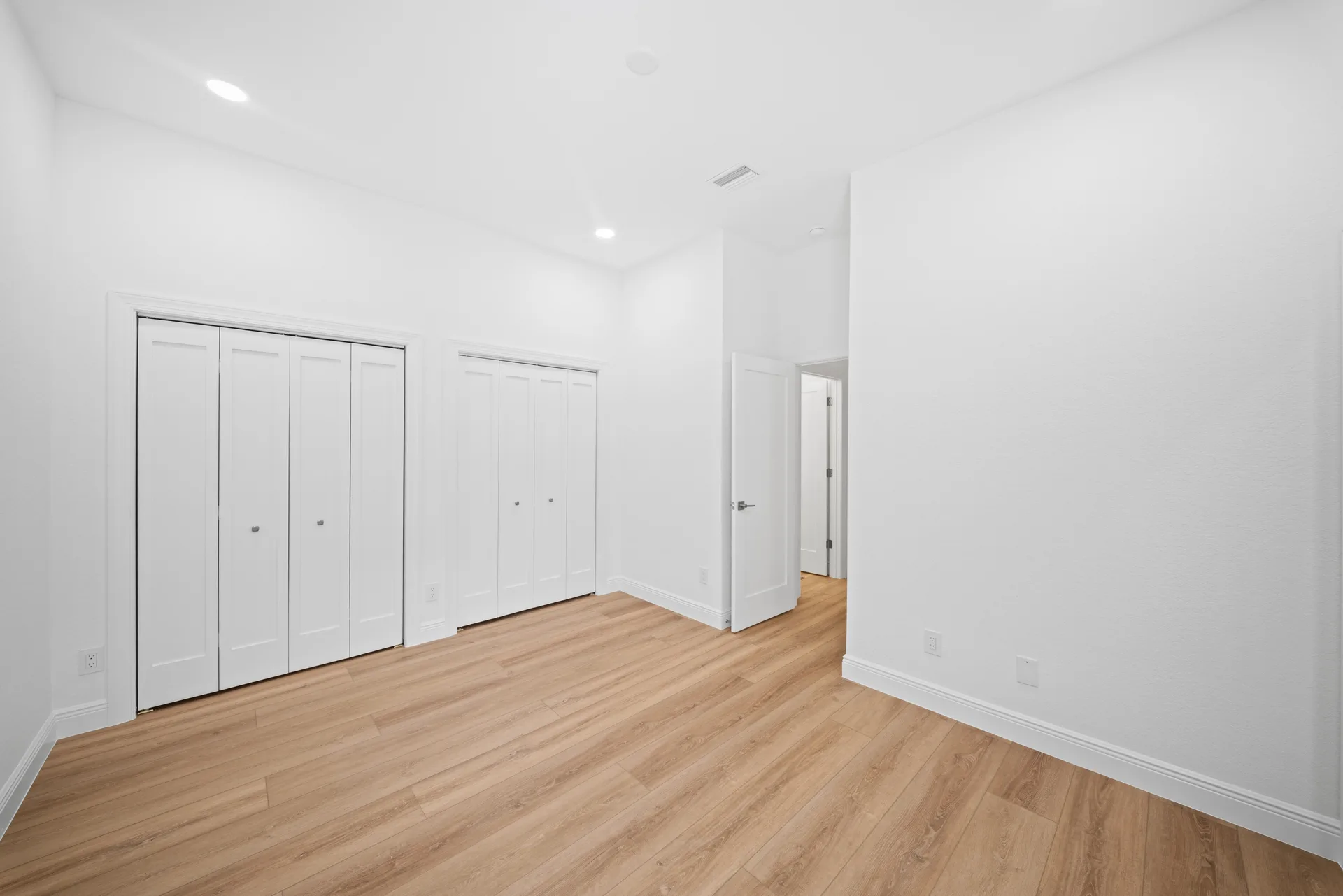 Empty secondary bedroom with light wood-look flooring