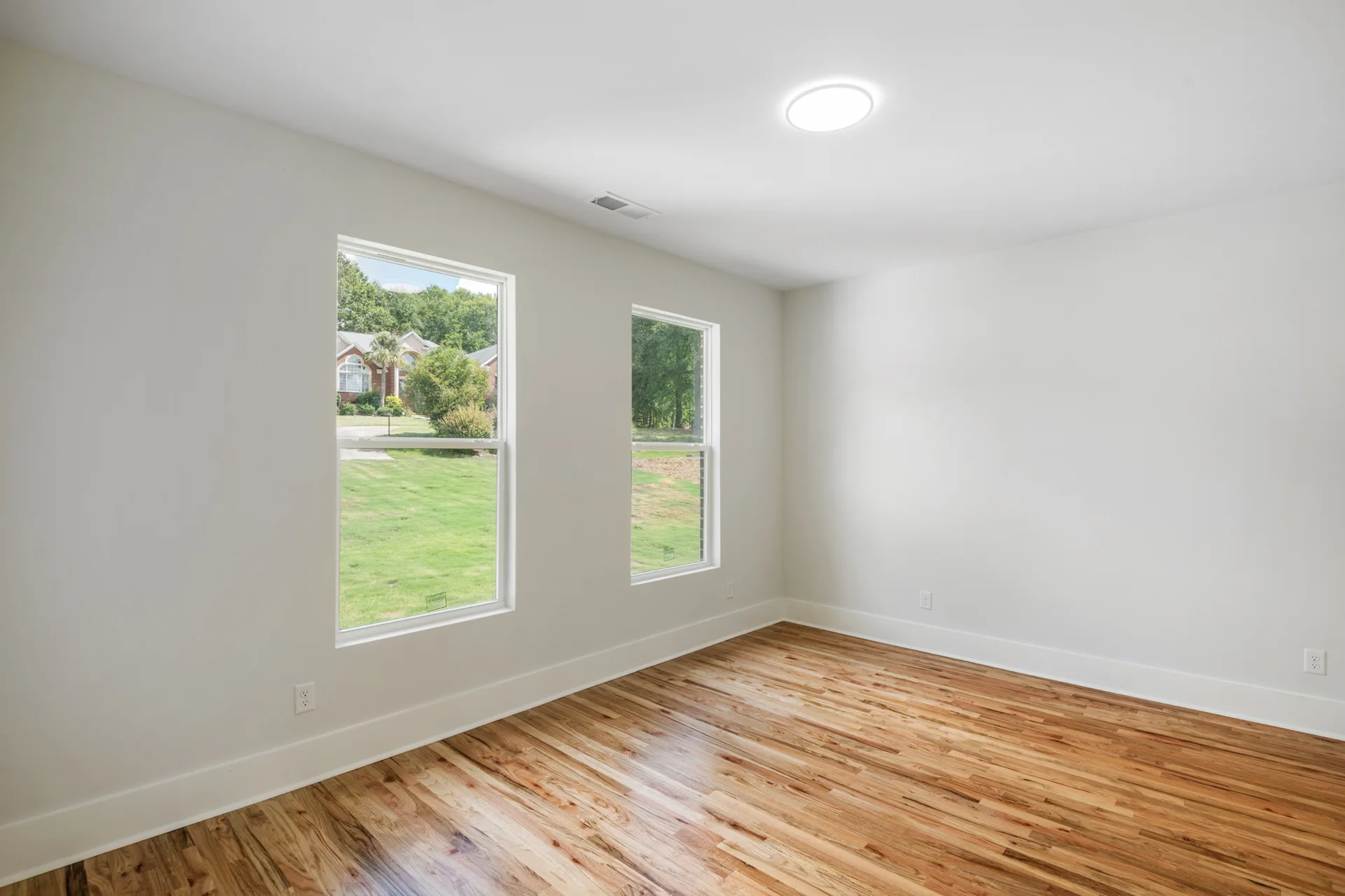 Secondary bedroom with two windows facing the yard