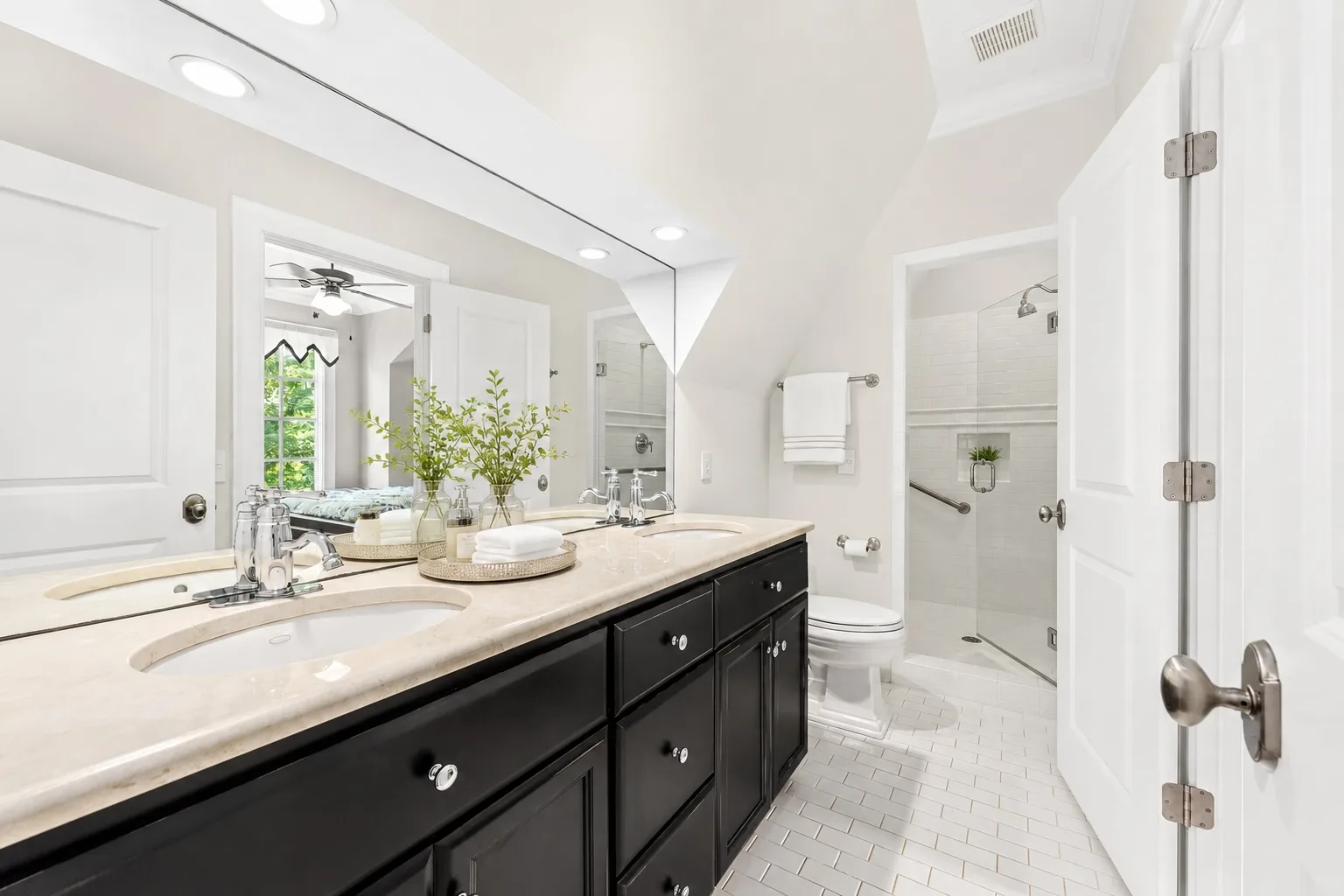 Primary bathroom with black vanity and stone countertop