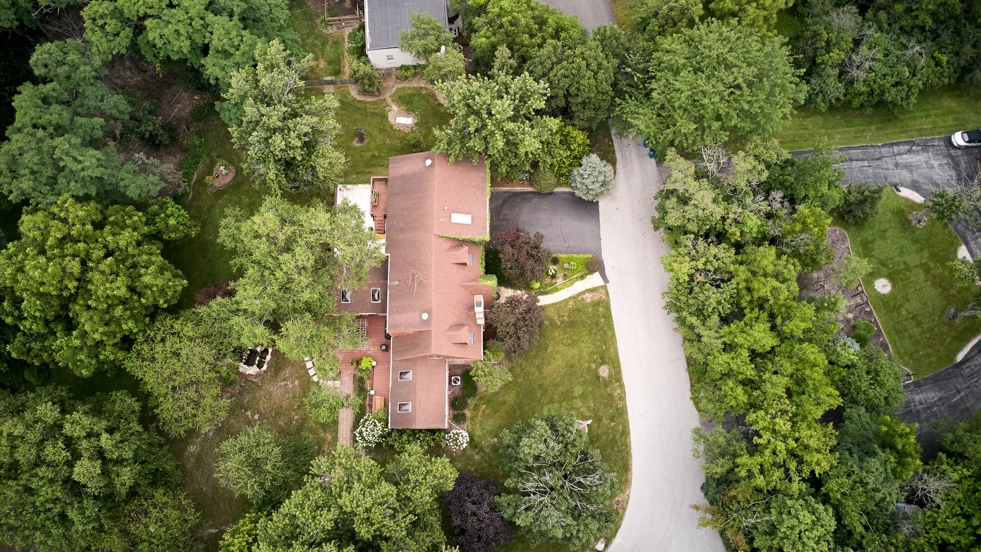 Top-down view of the home, skylights, and driveway