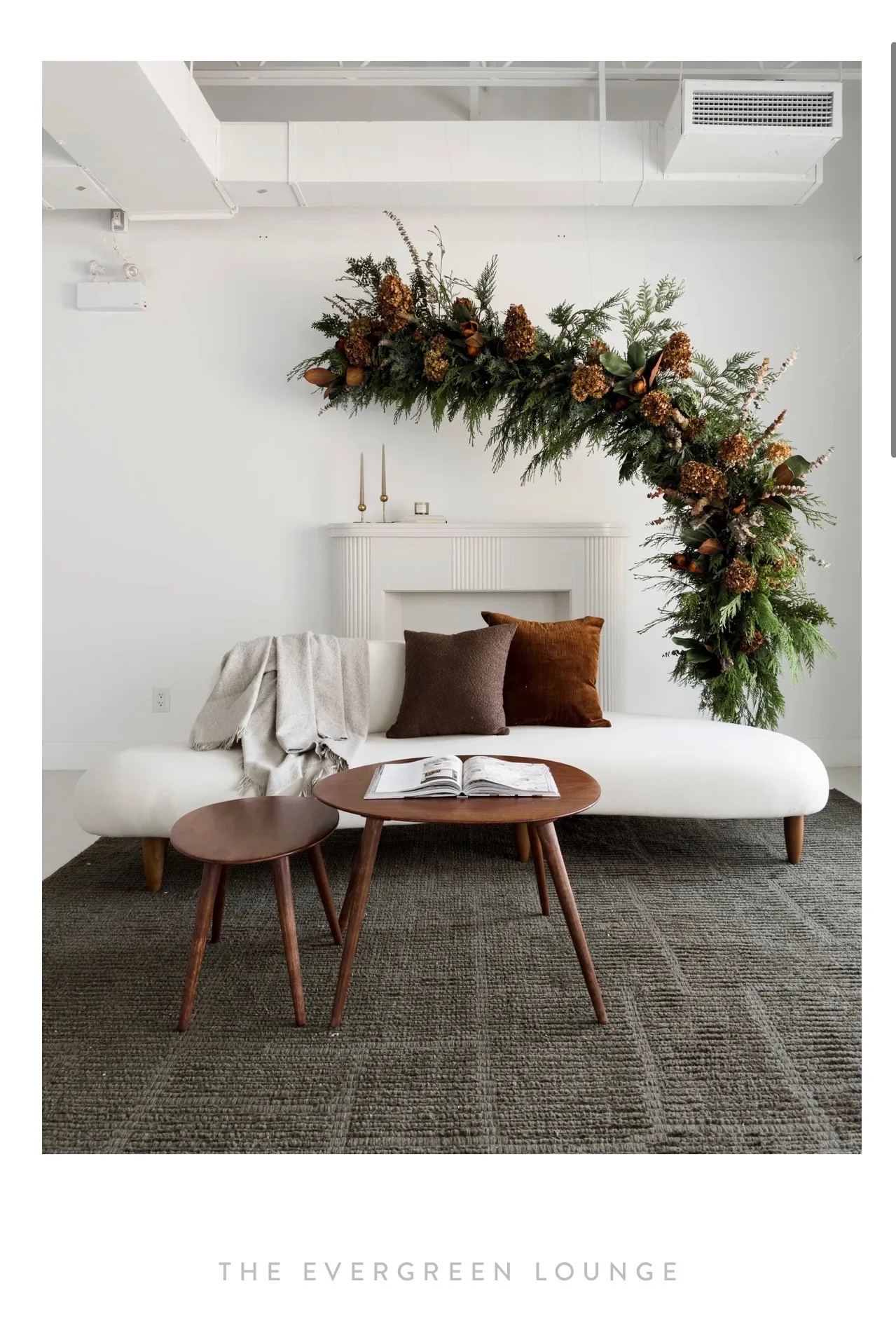 The Evergreen Lounge at The Nook Studio, a white sofa beneath a greenery arch