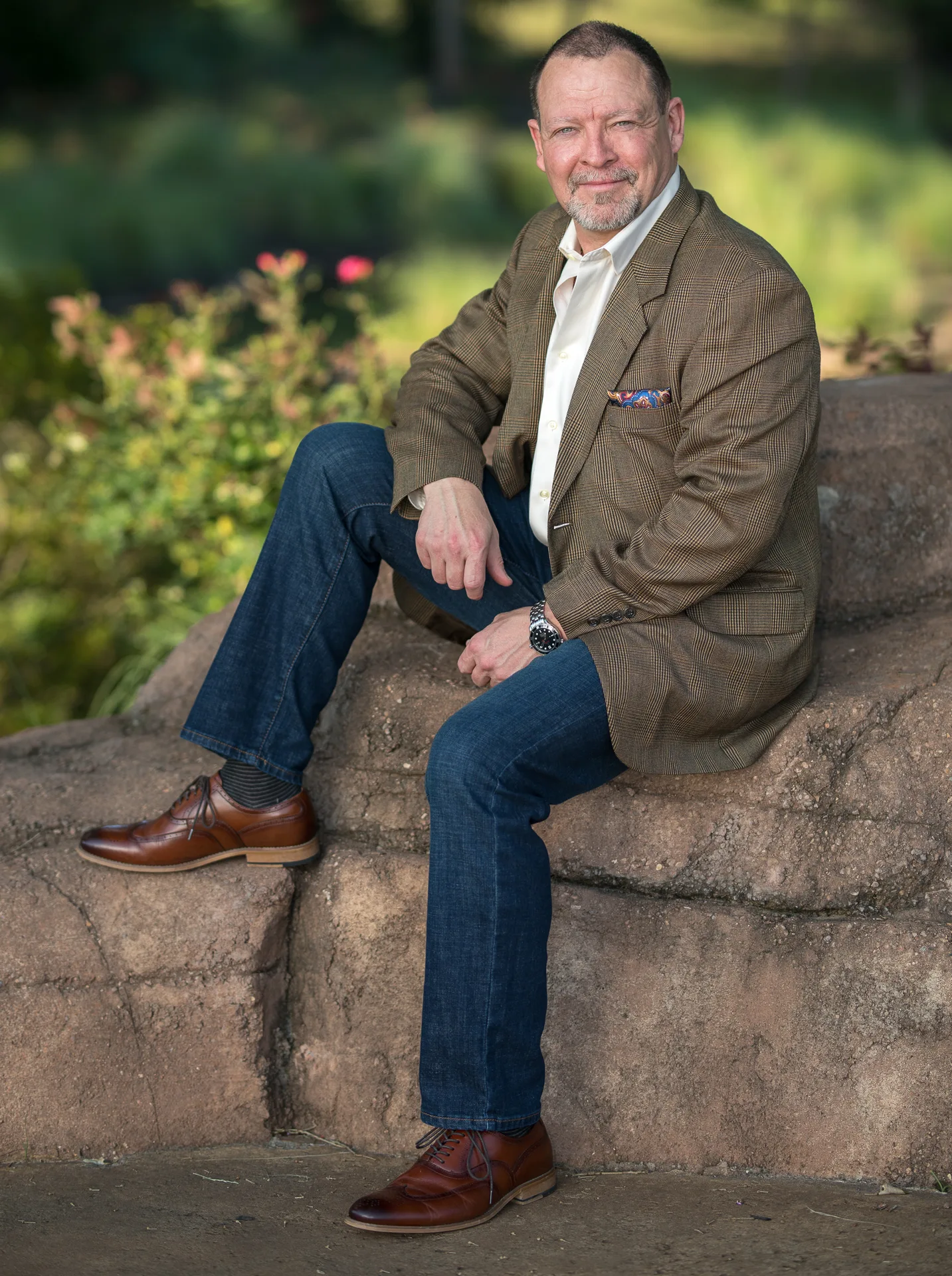 Guy Courtney Steib sitting on a rock in a brown jacket, outdoors