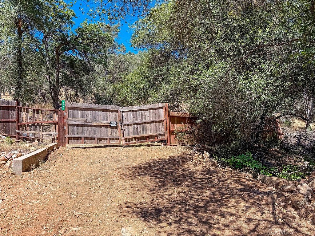 Sloped terrain with trees and natural vegetation on the Mariposa land for sale