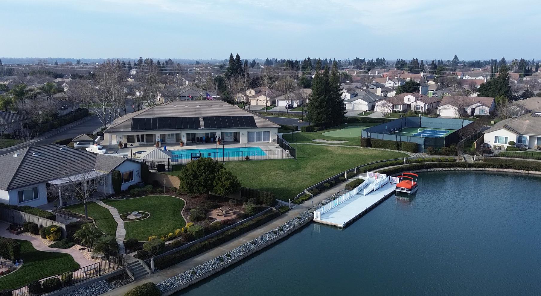 The lake with its floating dock and moored community boat at Heritage Lakeside in Elk Grove, California